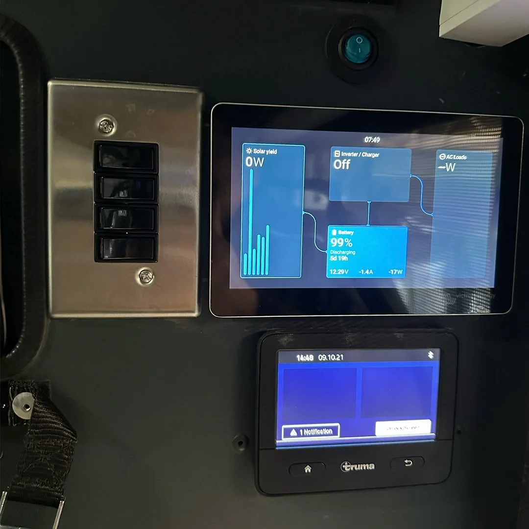 Close-up of two electronic control panels on a dark surface. The larger panel displays solar energy and battery information, while the smaller panel below shows notifications.