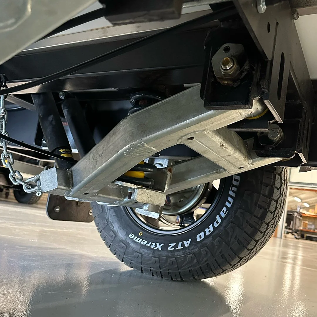 Close-up of a vehicle's underside showing the suspension, frame, and a large off-road tire marked 'DURAPRO A/T 12 Extreme'.