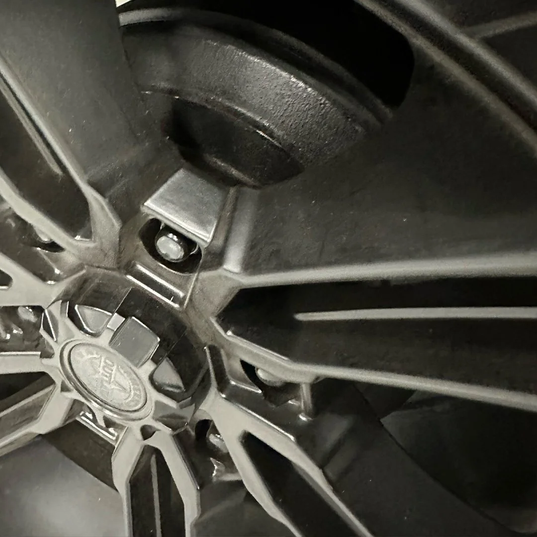 Close-up of a car tire with a metallic rim, with the hubcap showing the brand logo of ACDelco.