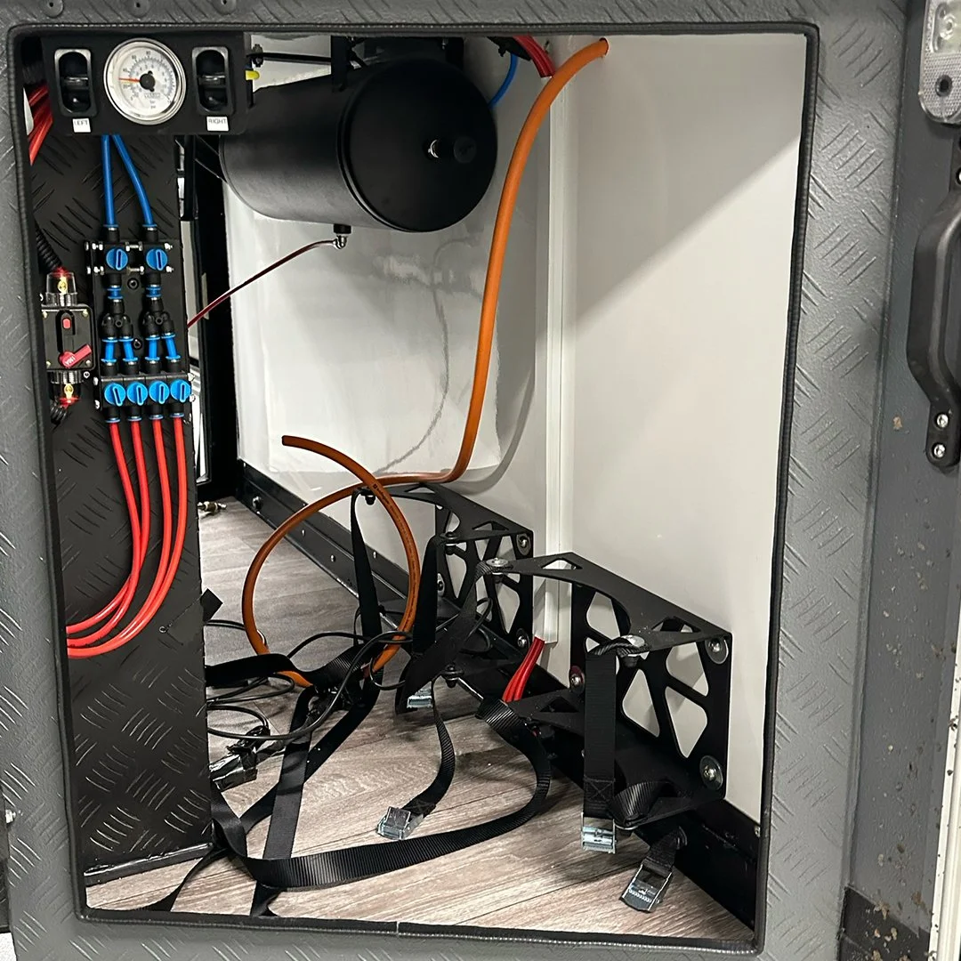 Interior of an electronic or mechanical device enclosure with wiring, tubing, a black cylindrical component, and circuit components visible.