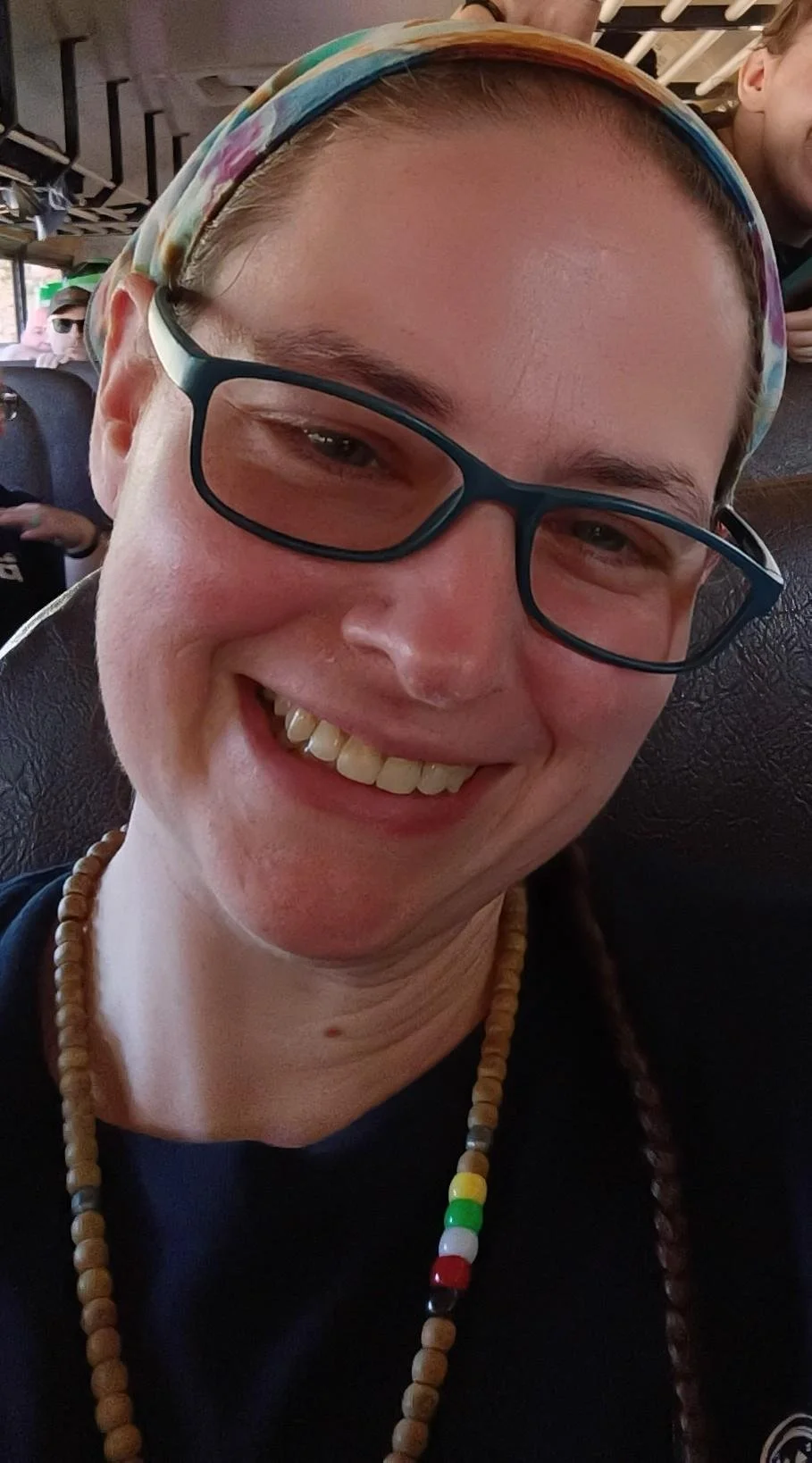 The image contains a white woman with glasses and wearing a bandana.