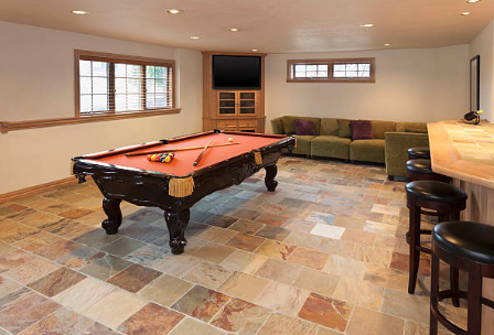 Game room with a pool table, seating area, tiled floor, and bar stools.