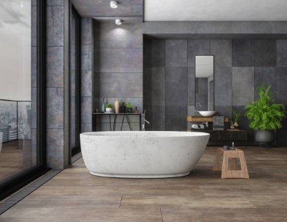 Modern bathroom with freestanding white bathtub, wood flooring, large windows, and decorative plants. Roofing and painting in Bucks County