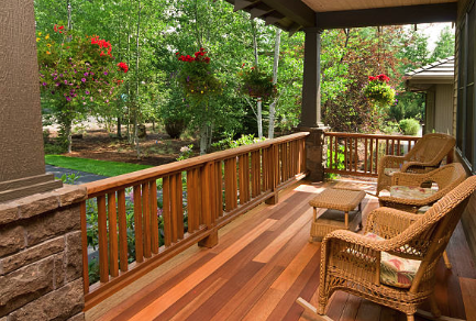 Wooden porch with wicker furniture and hanging plants