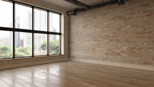 Empty loft space with brick wall and large windows Roofing and painting in Bucks County