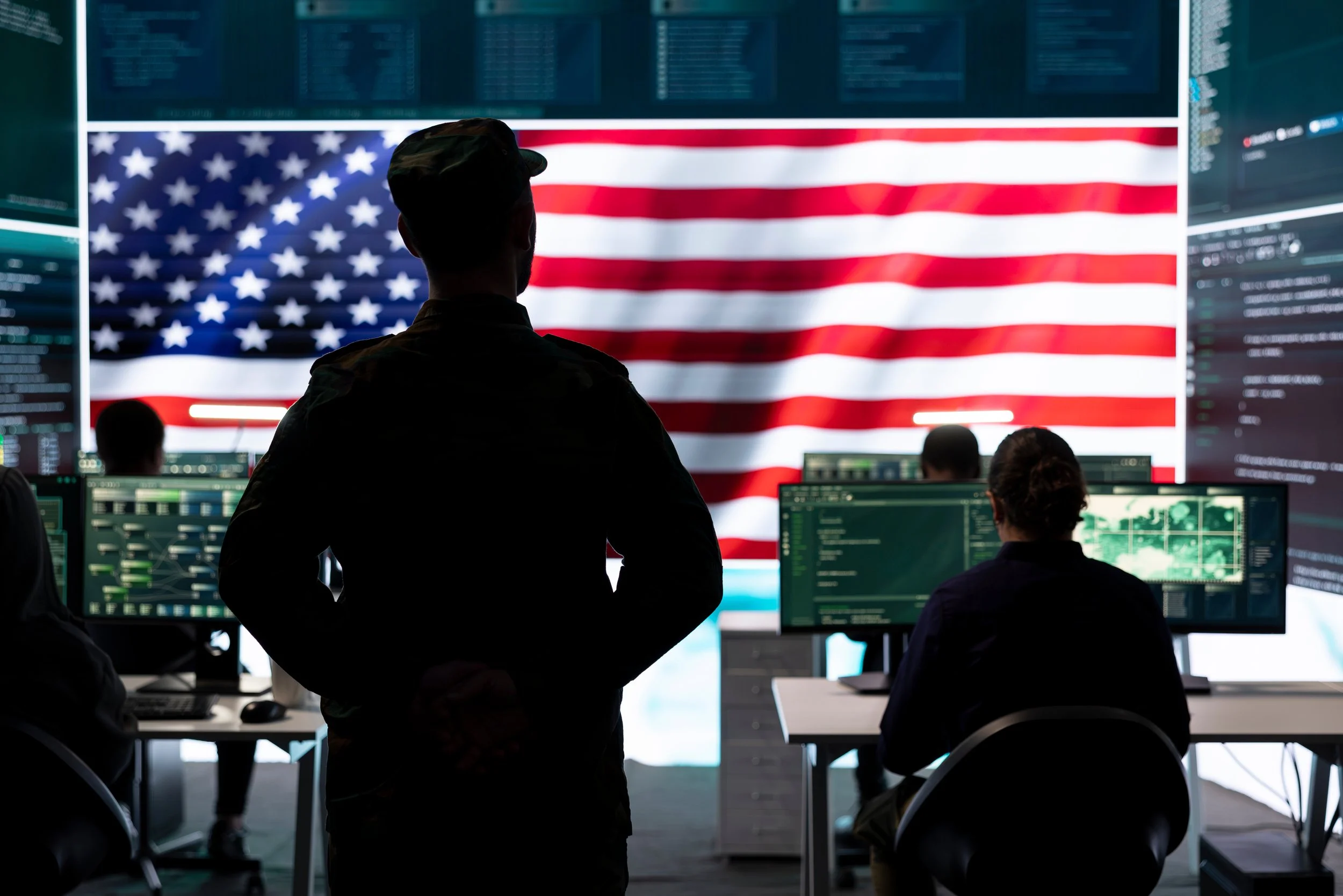 Large American flag hanging in a spacious industrial warehouse with reflective floor.