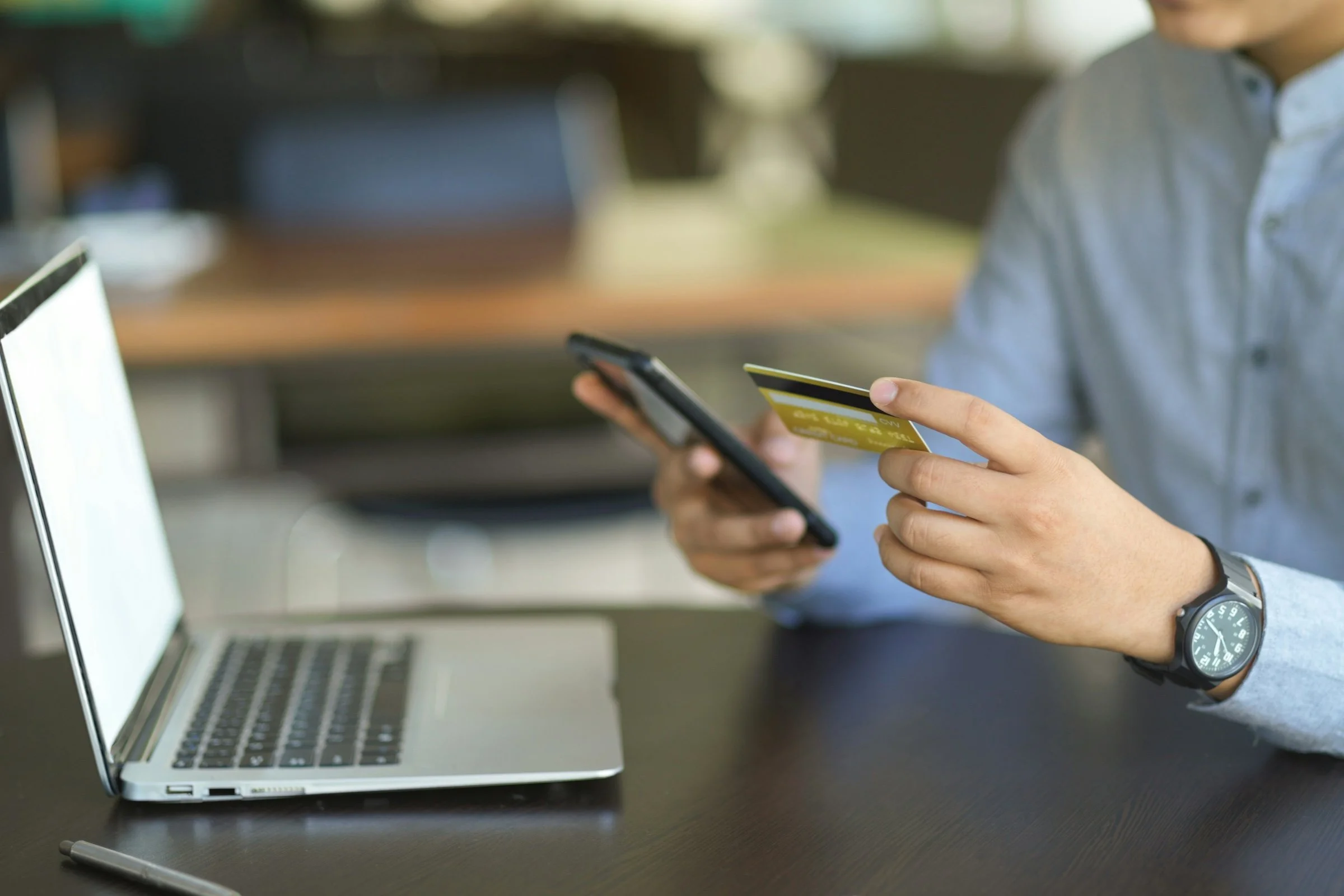 a person holding a credit card and smartphone