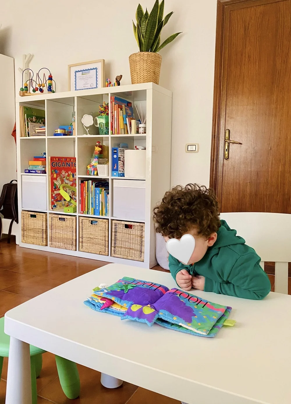 Bambino sfoglia un libro colorato al tavolino dello studio di logopedia riabiliTIAMO a Messina