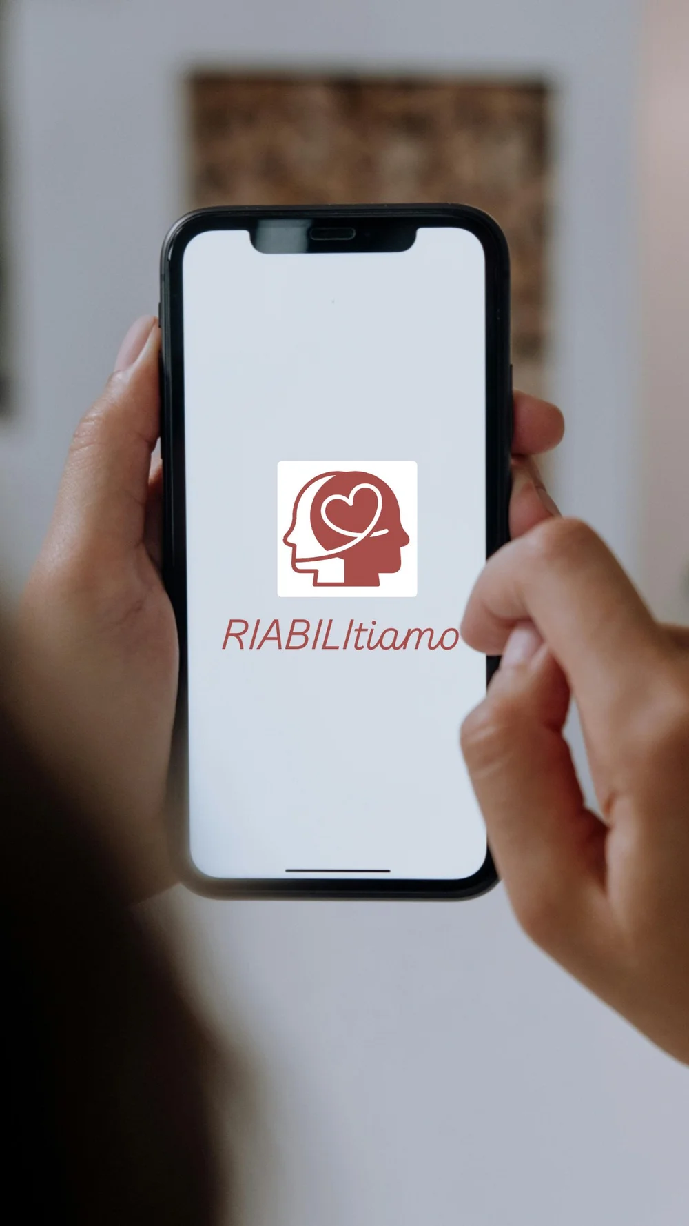 Smartphone con il logo di riabiliTIAMO sullo schermo