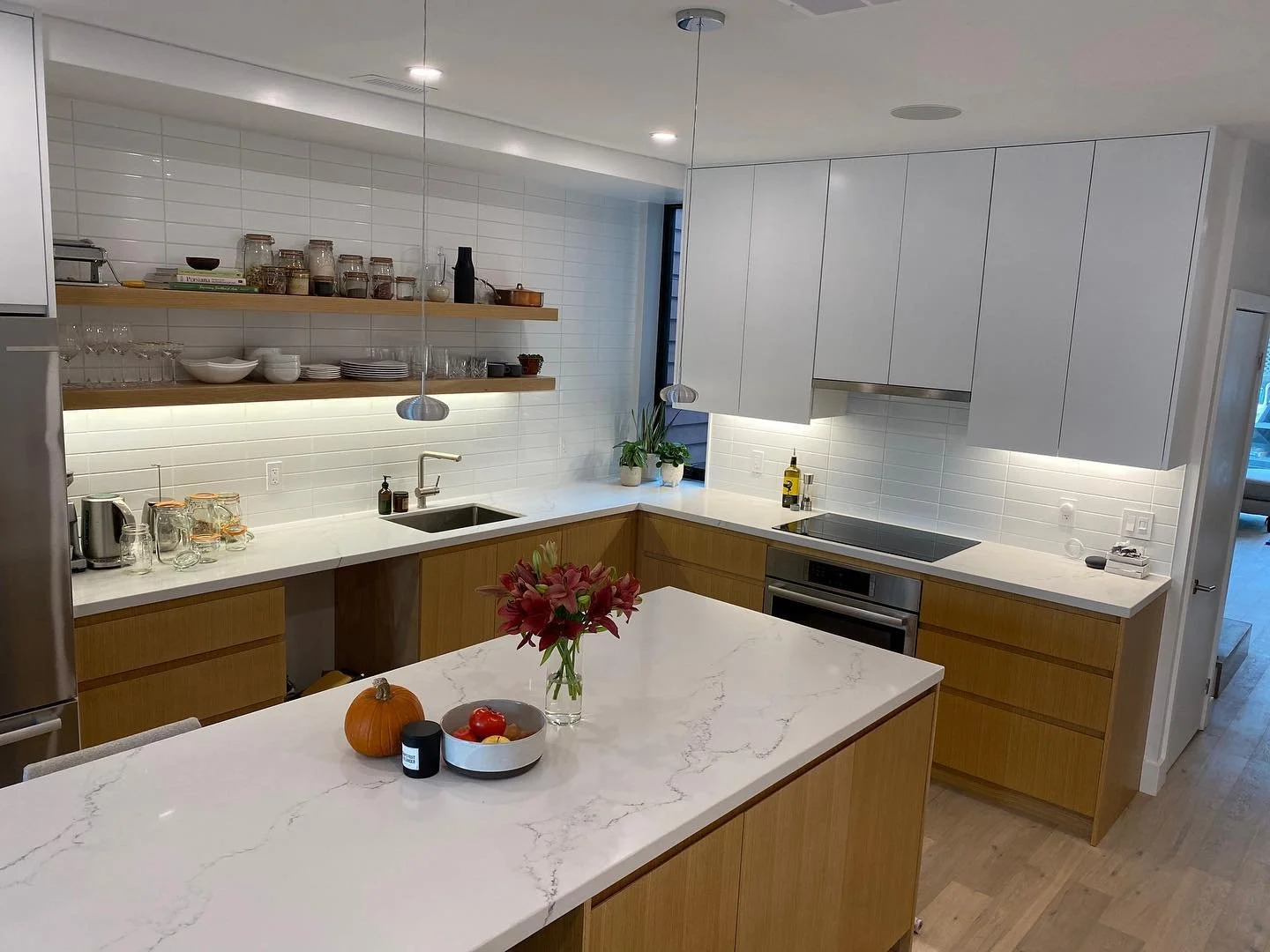 White oak cabinetry goes great with the white quartz countertop and backsplash combo