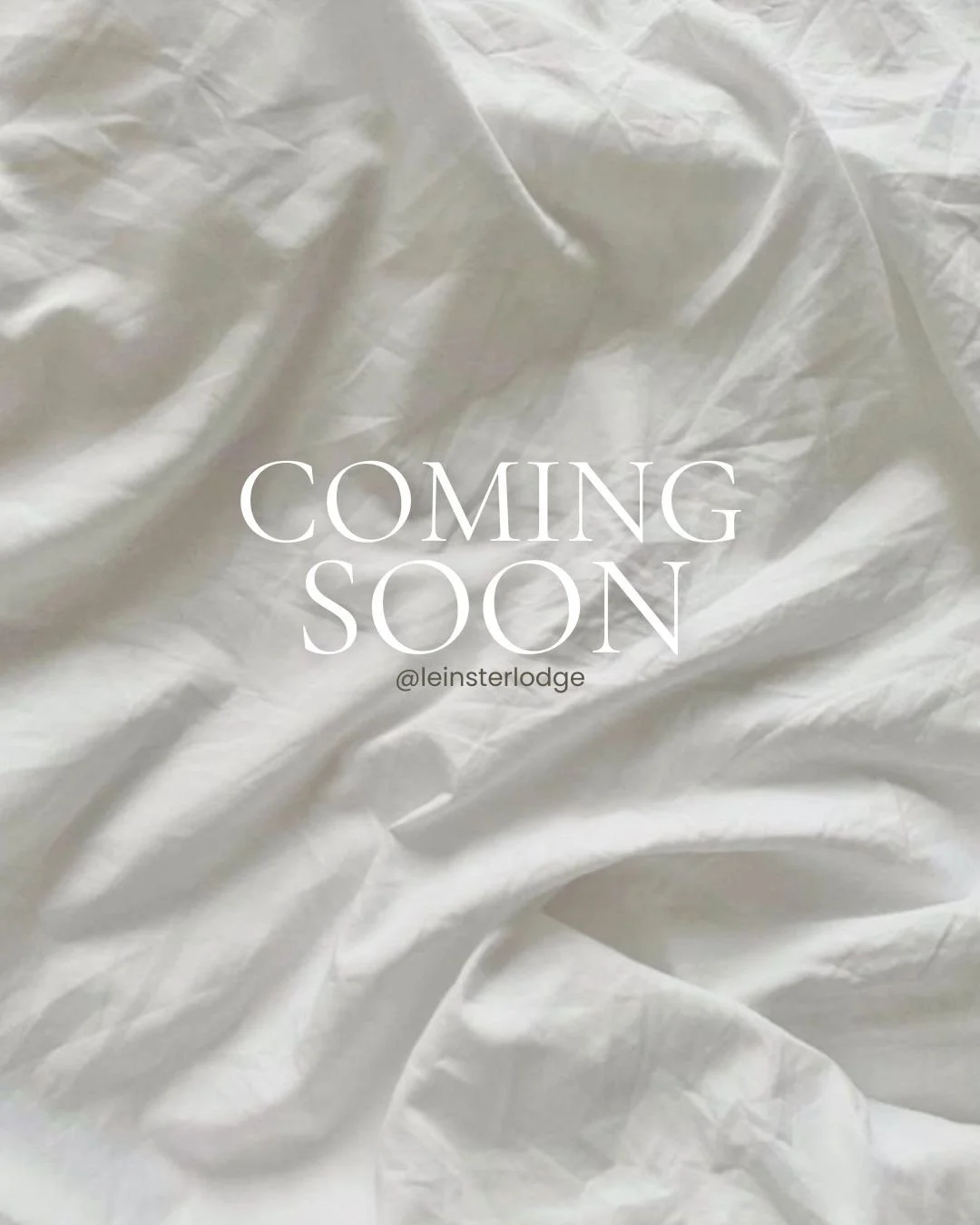 Text saying 'Coming Soon' on a crumpled white fabric background, with a small '@leinsterlodge' handle below.