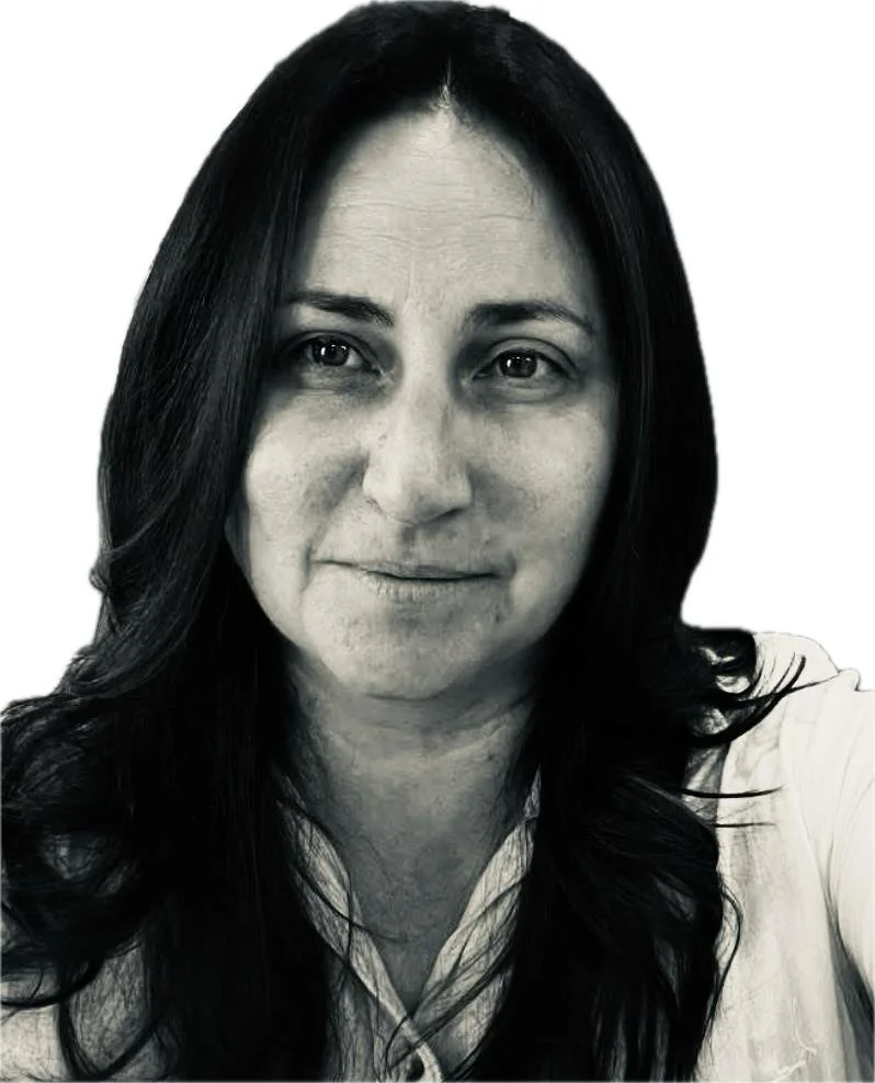 A photo f Kristy Grant, a Black and white close-up portrait of a woman with long dark hair, light skin, smiling slightly, wearing a collared shirt.