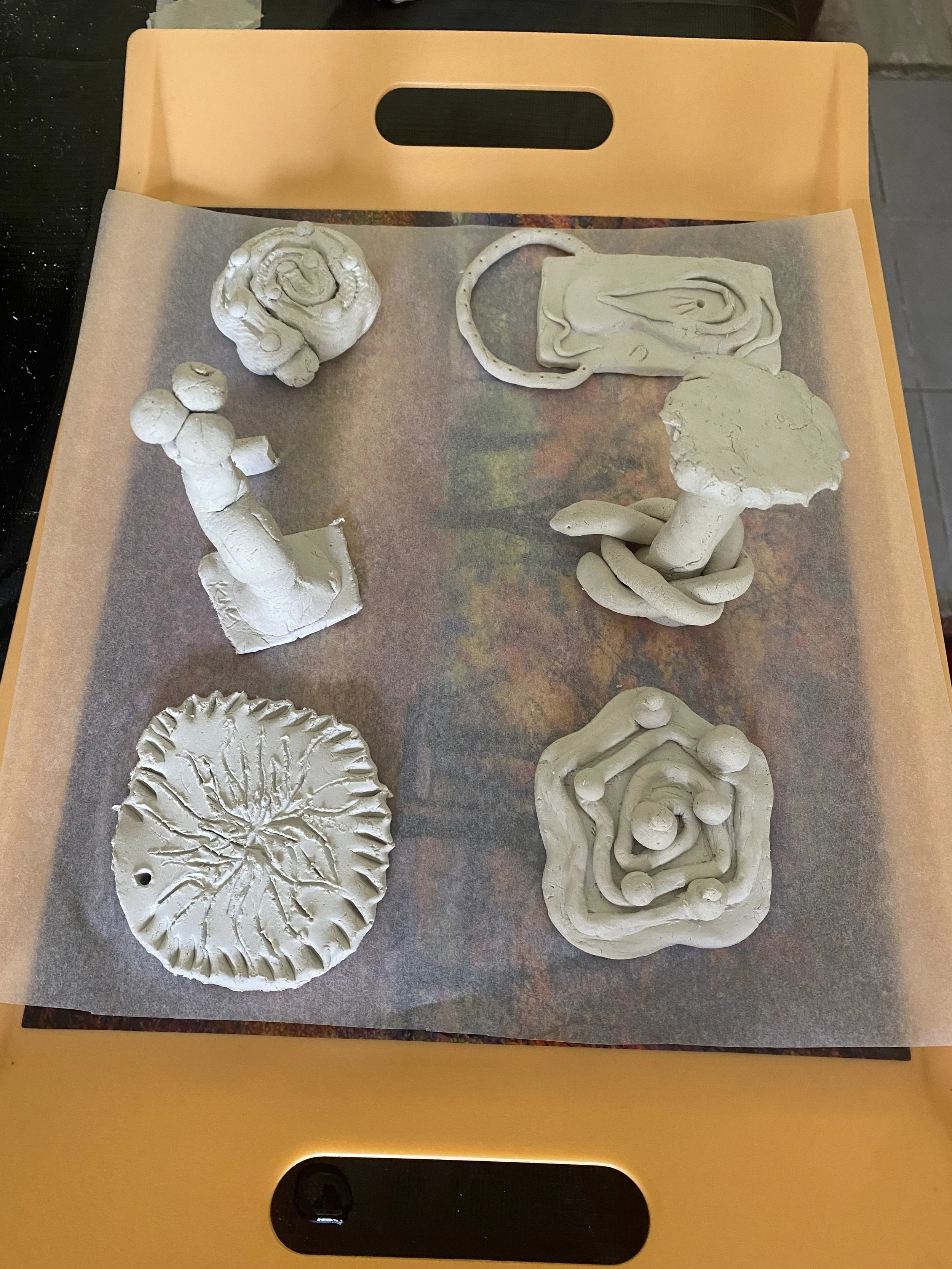 Air dry clay amulets by participants