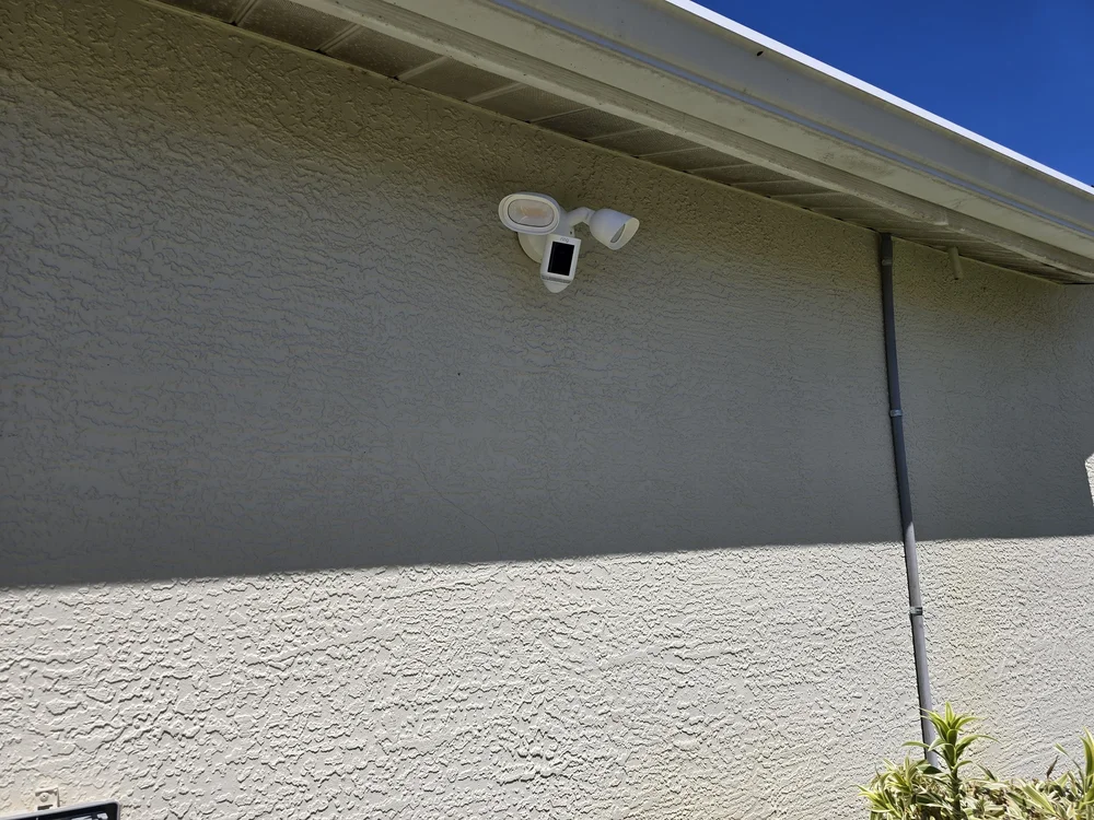 Ring floodlight camera installed on concrete exterior wall in Naples
