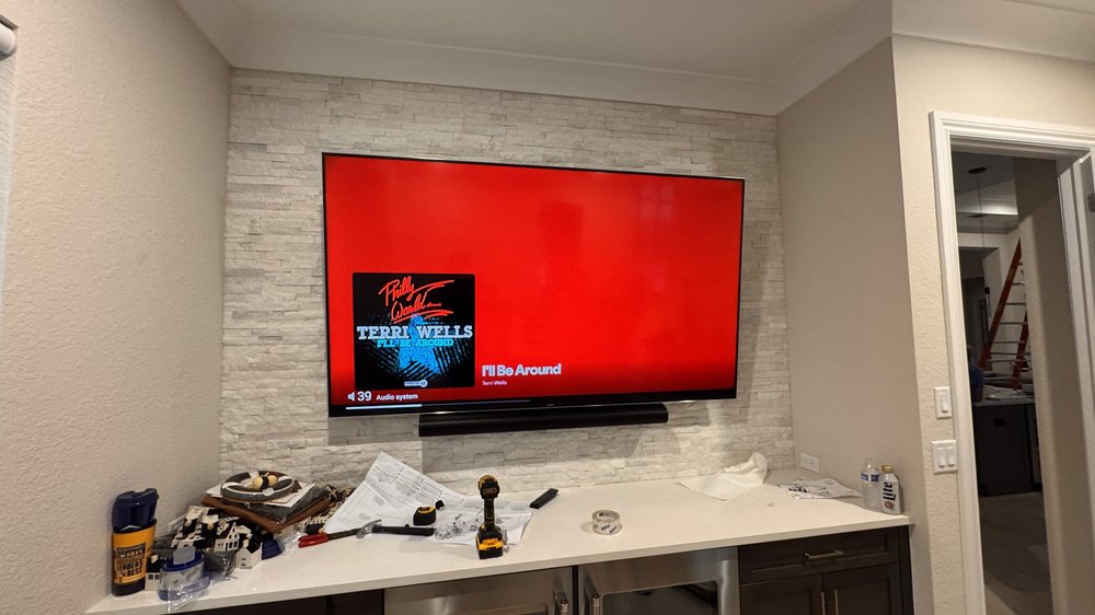 Living room with mounted TV on stone accent wall