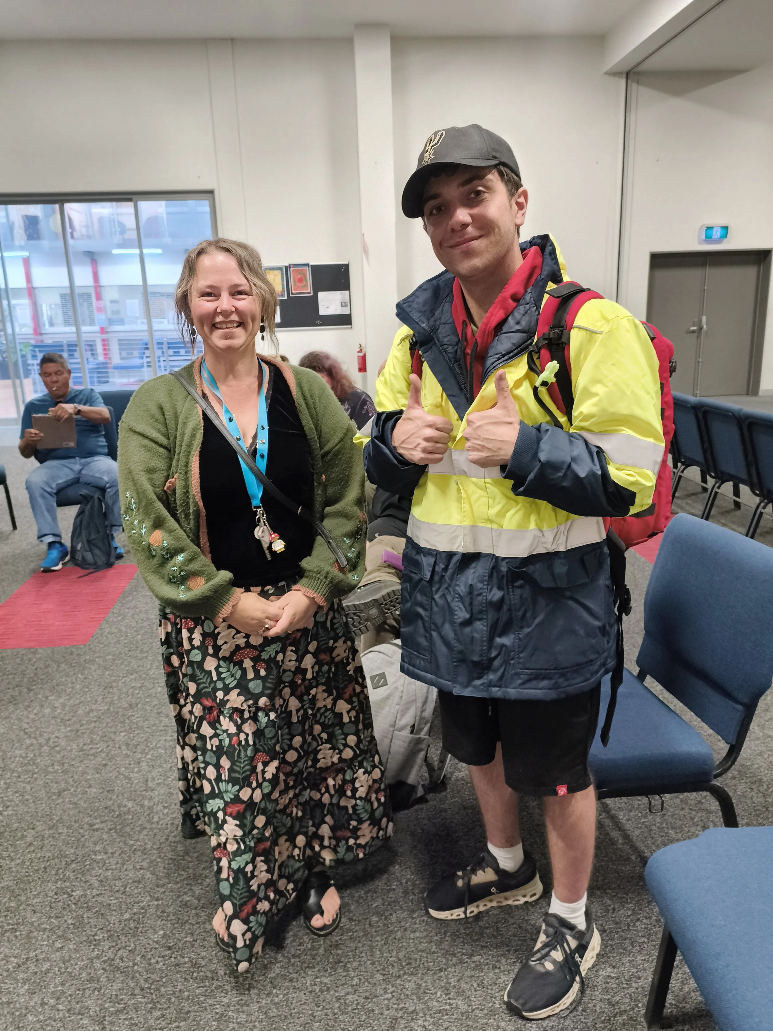 Three people working together to build a tower out of marshmallows and spaghetti. 