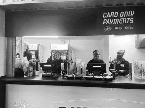 Retail and hospitality team serving customers at a counter