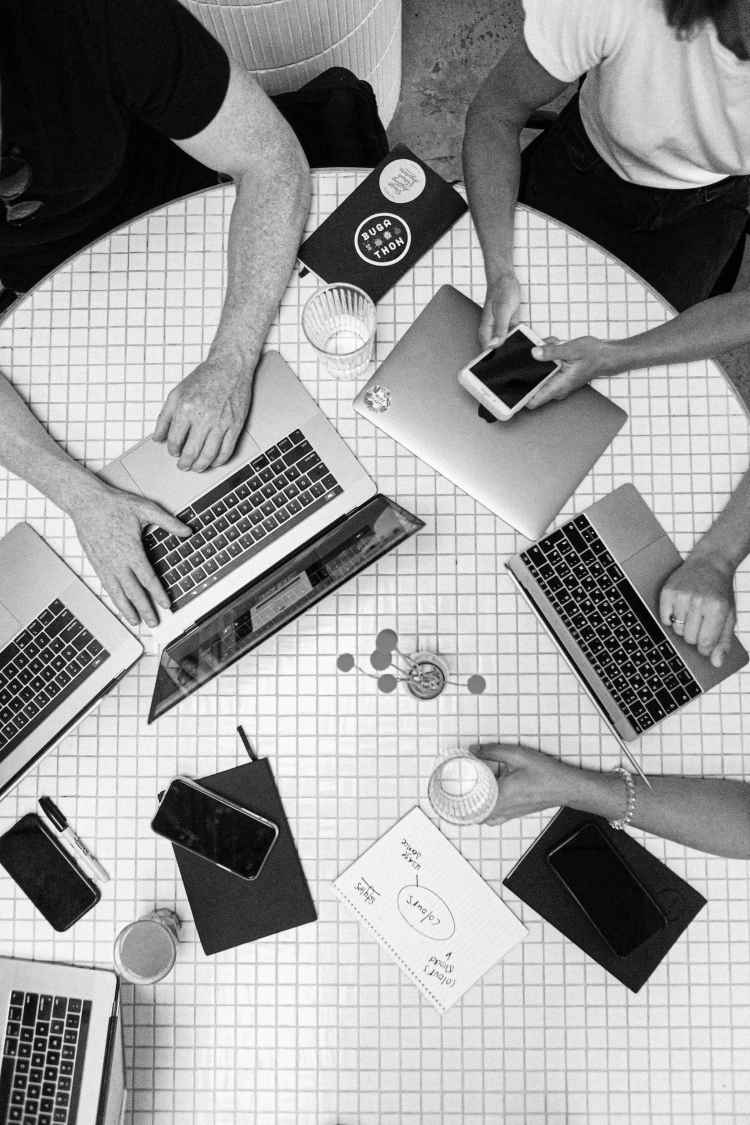 Office team collaborating around a table with laptops
