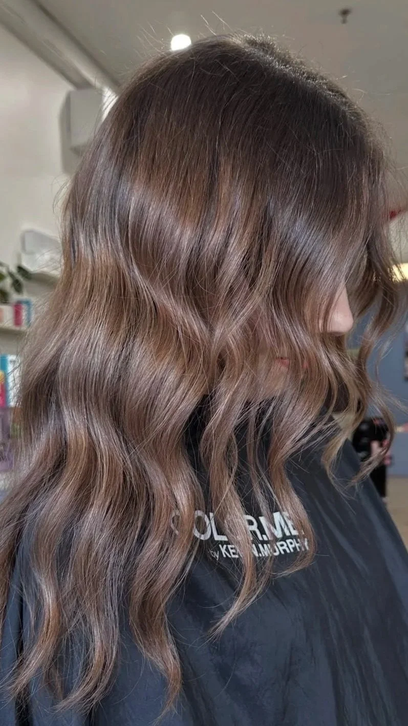 brunette hair colour with long wavy hair coloured by emerging stylist