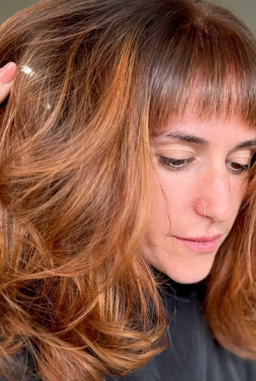 Close-up of wavy reddish-brown hair with subtle highlights.