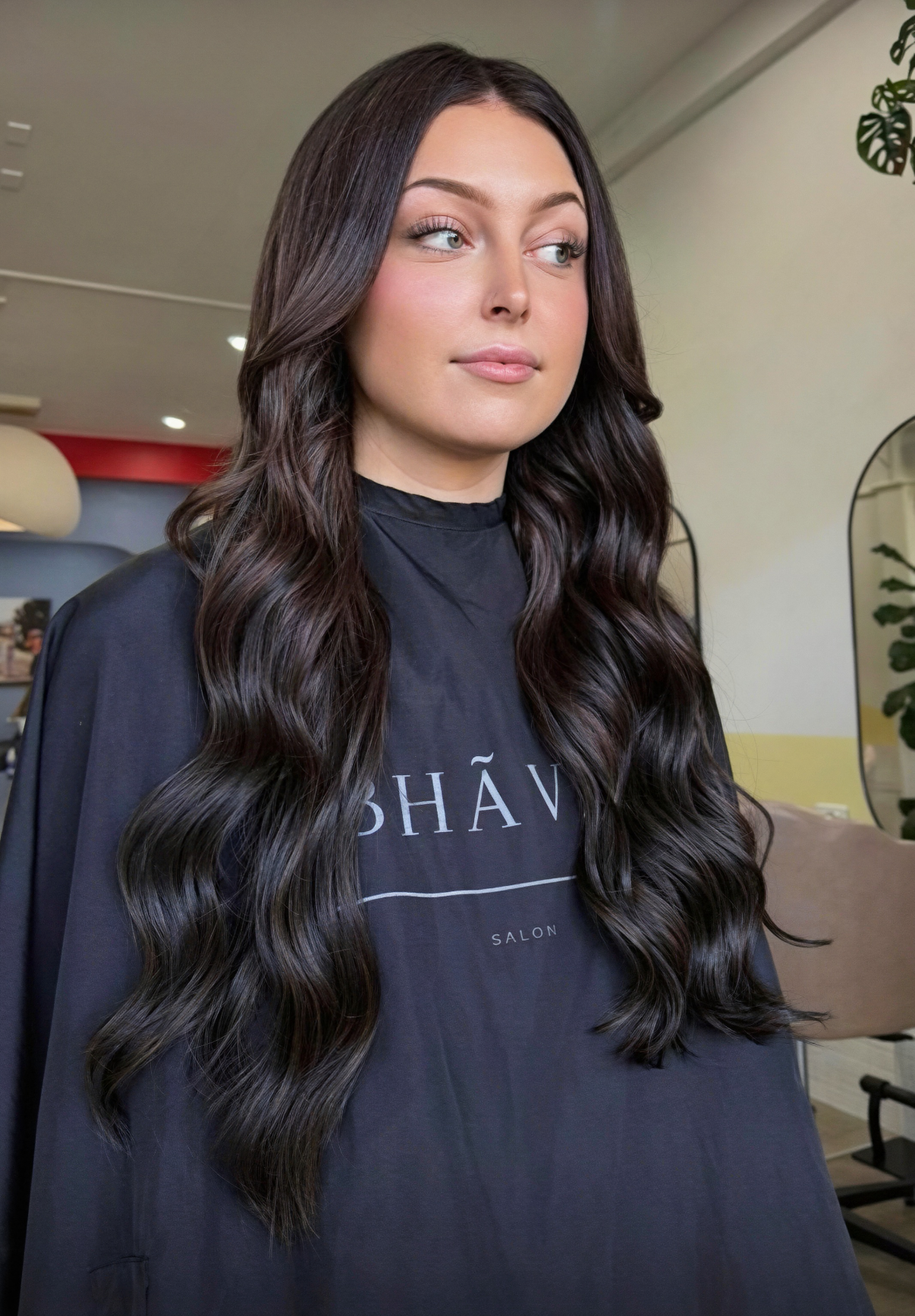 Long, glossy brunette hair extensions styled in loose waves at Bhãva Salon in Teneriffe.