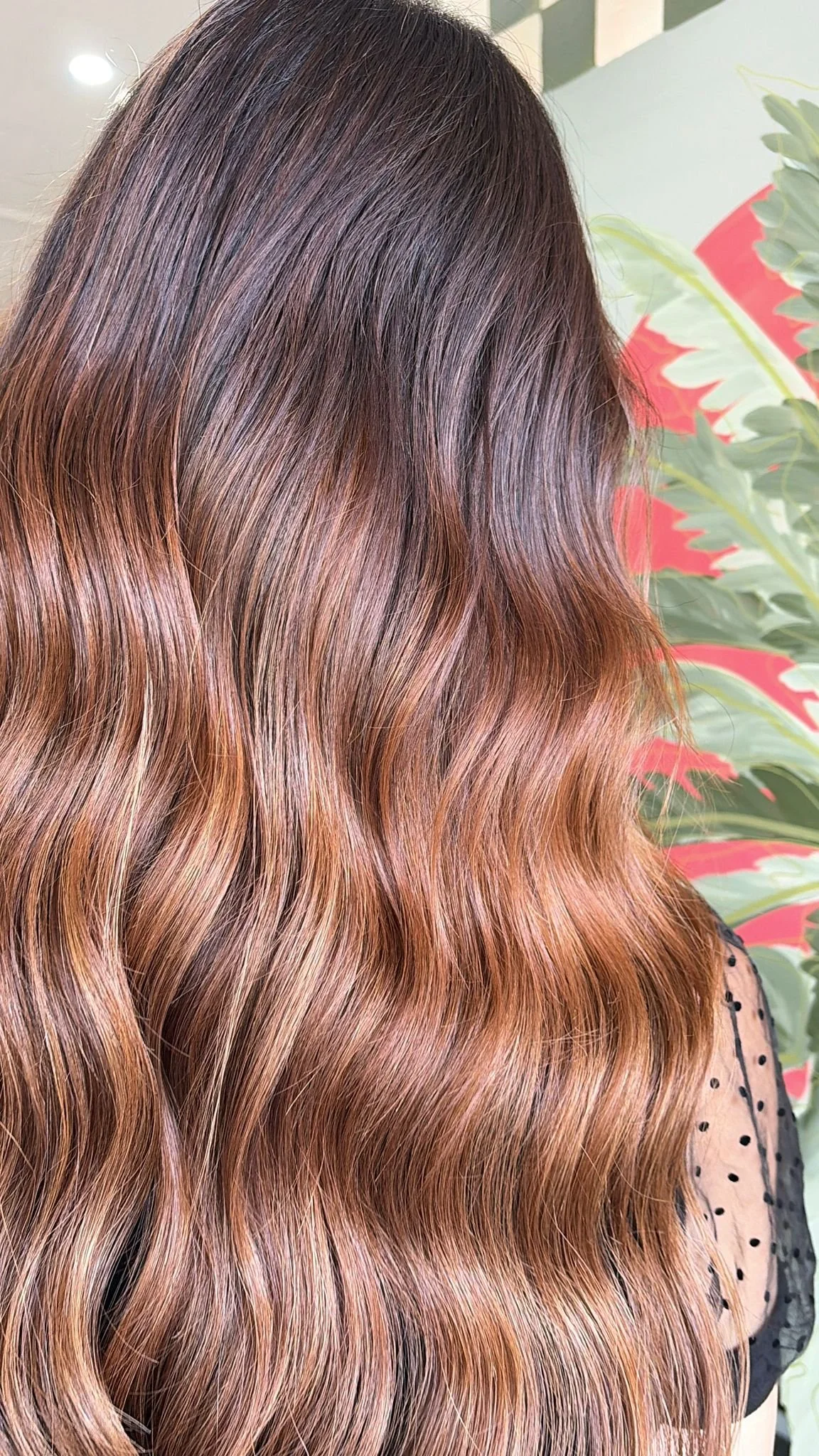 Wavy long extensions in hair with a copper and brunette colour