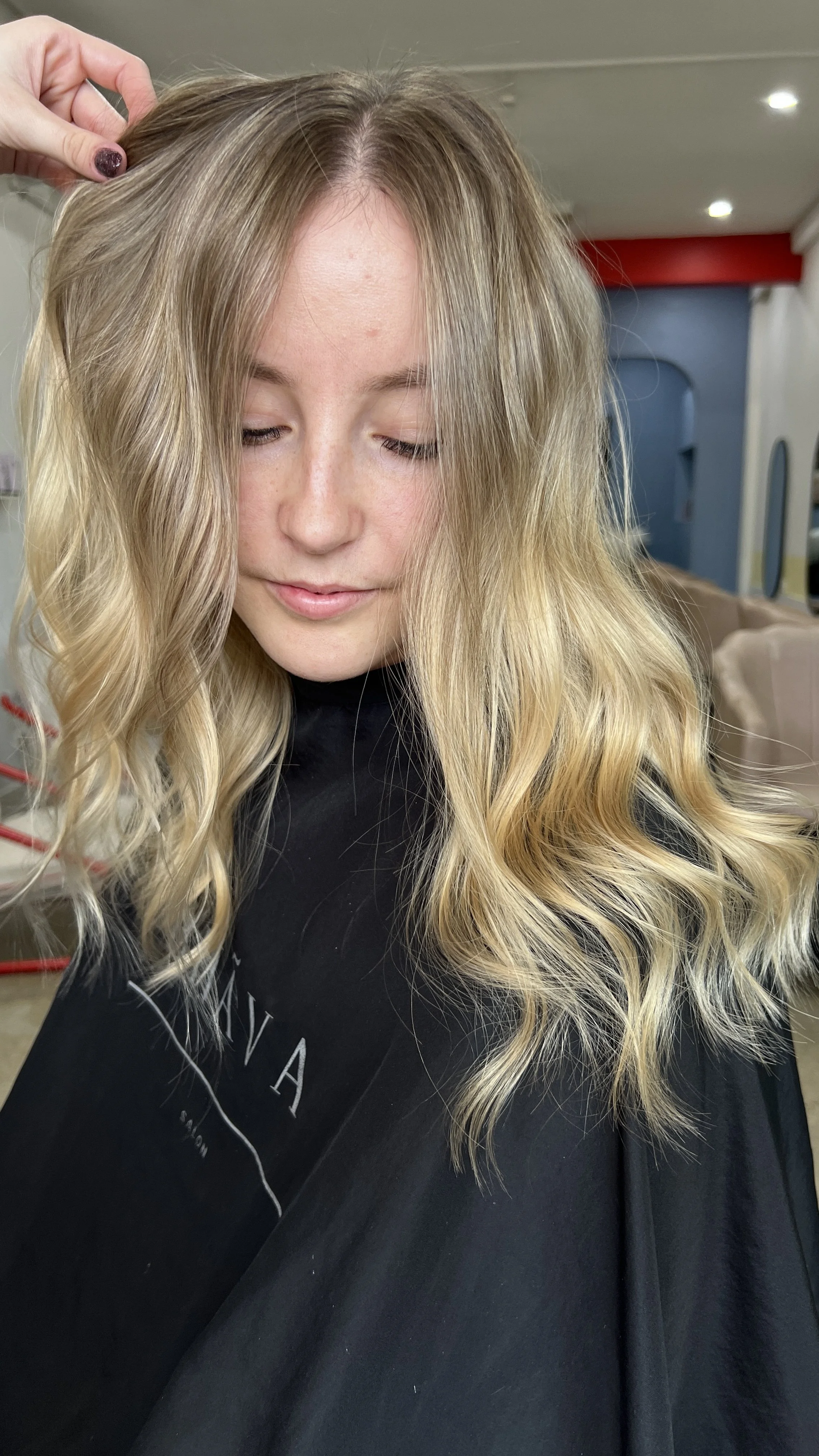 Woman with long, wavy blonde hair and butterfly tattoo on shoulder