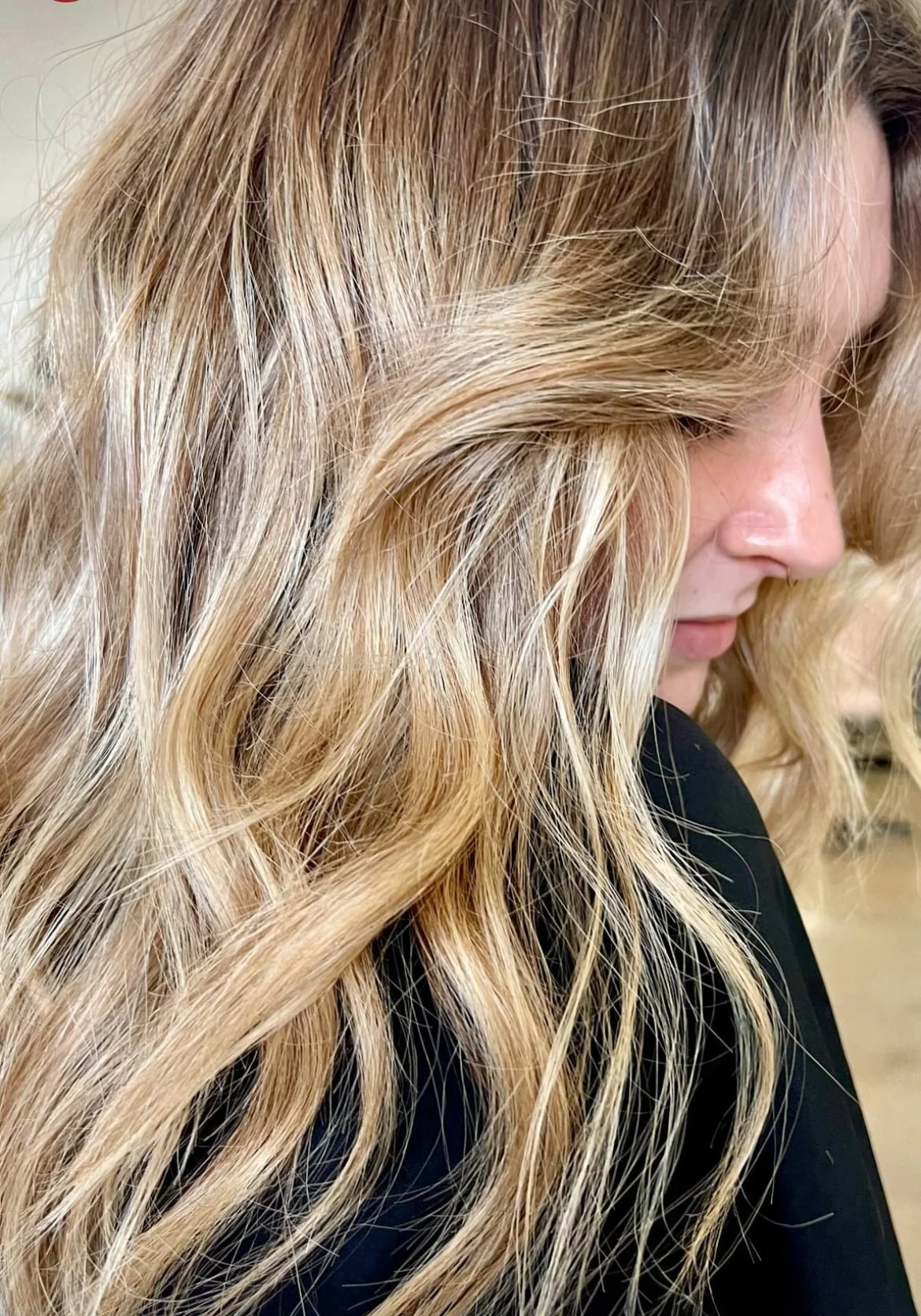 Wavy blonde balayage hair in a salon.