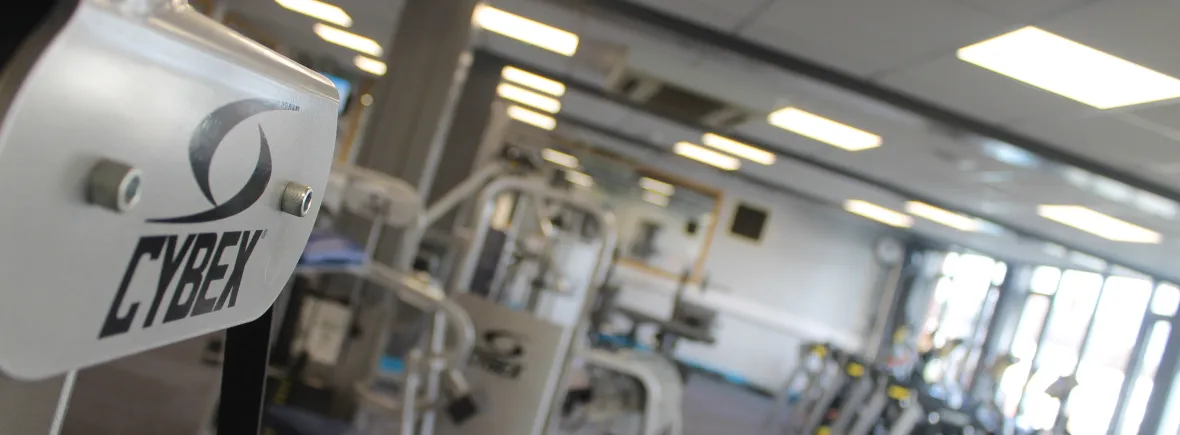 Gym interior with Cybex equipment, focus on logo.