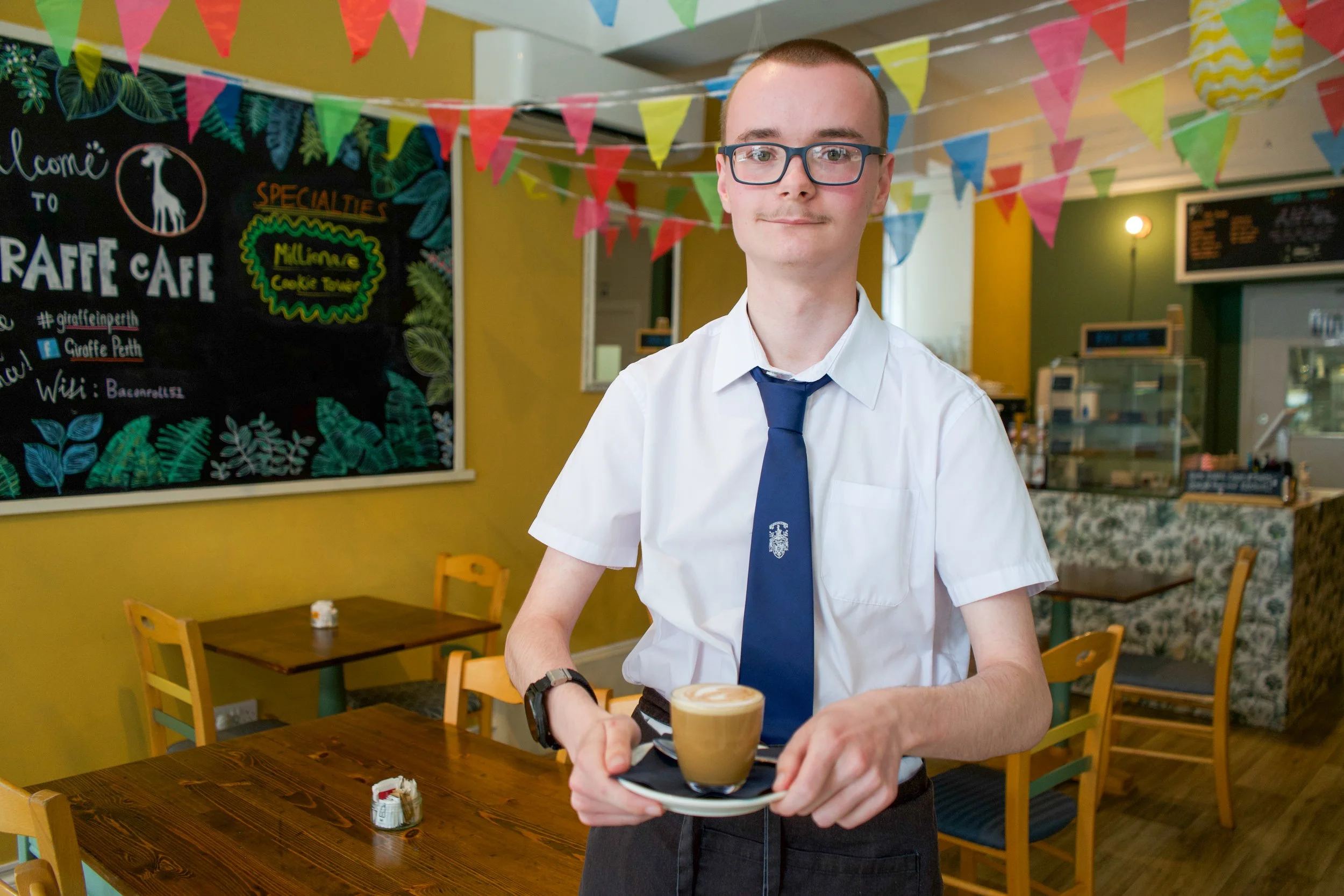 Giraffe Café trainee holding a coffee