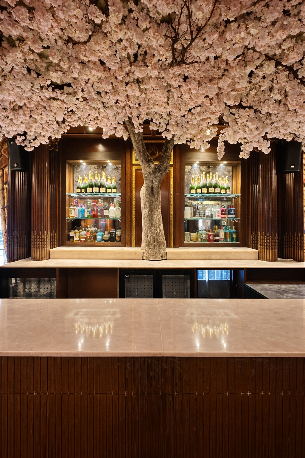 Sculptural artificial tree installation with pink blossom foliage species