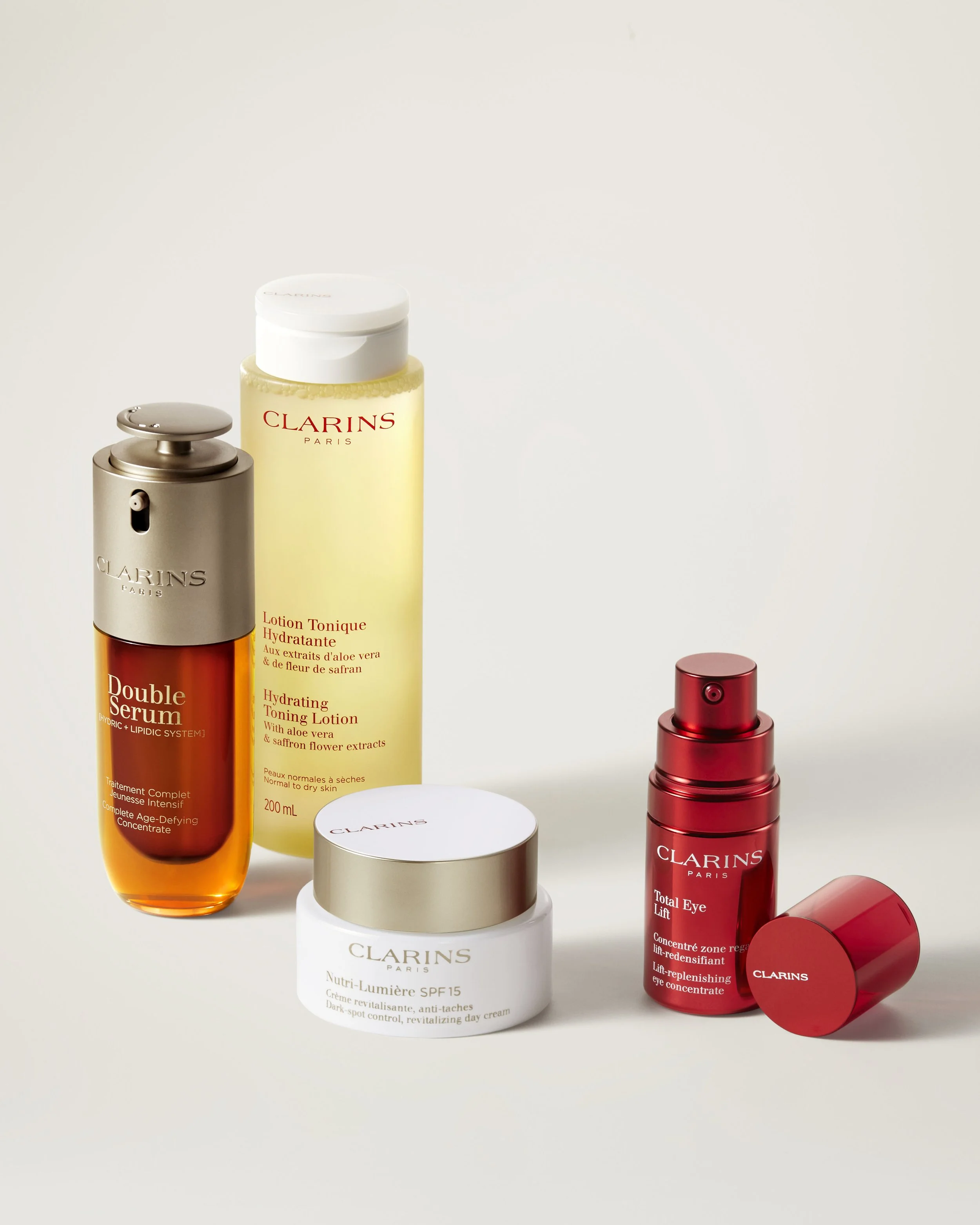 Produits de soin Clarins, comprenant une lotion tonique hydratante, un sérum double, une crème Nutri-Lumière SPF 15, et un concentré pour les yeux.