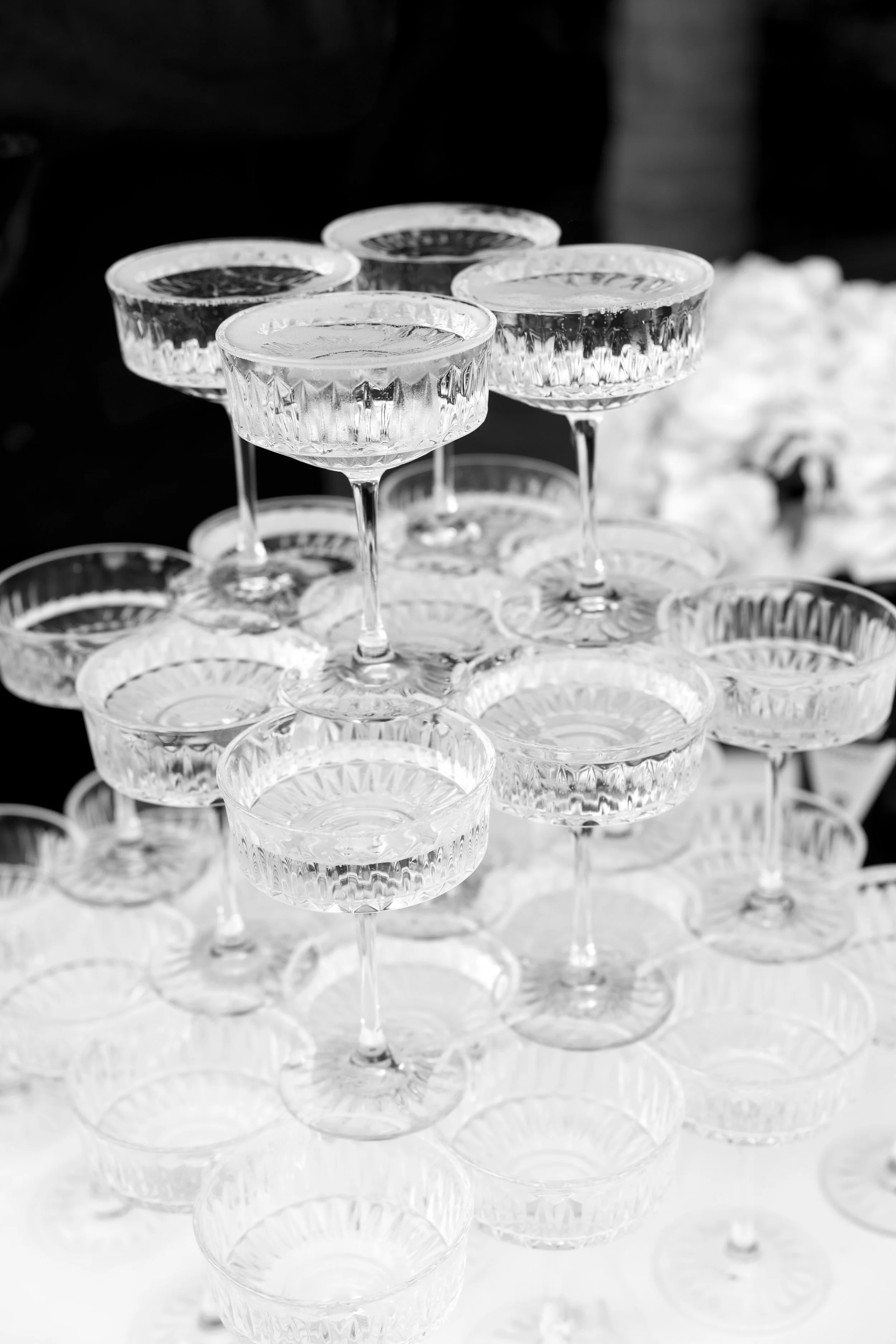 Stacked crystal coupe glasses with lemon slices on top, arranged for a celebration or event.