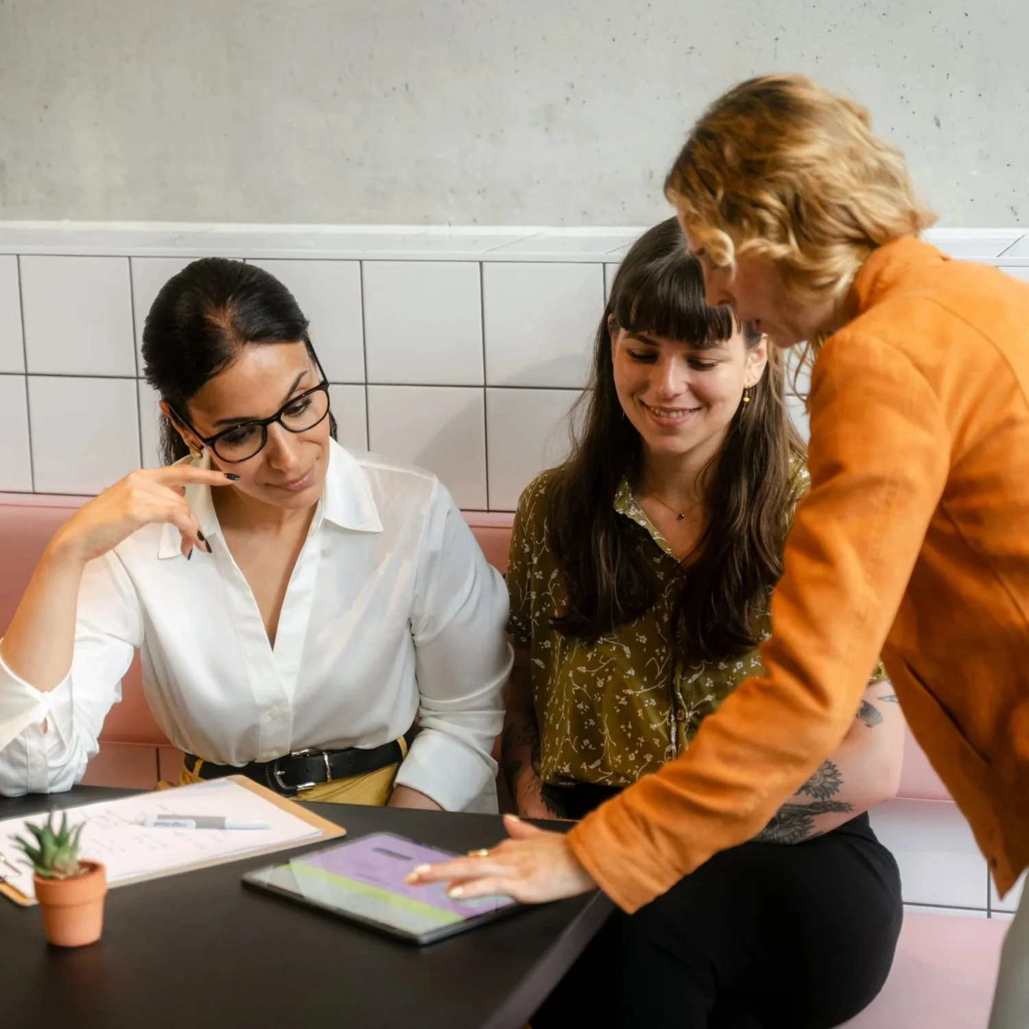 People working together around a tablet at an AI EMPOWER event