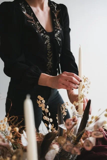 Wedding florist installs candles among a detailed tablescape