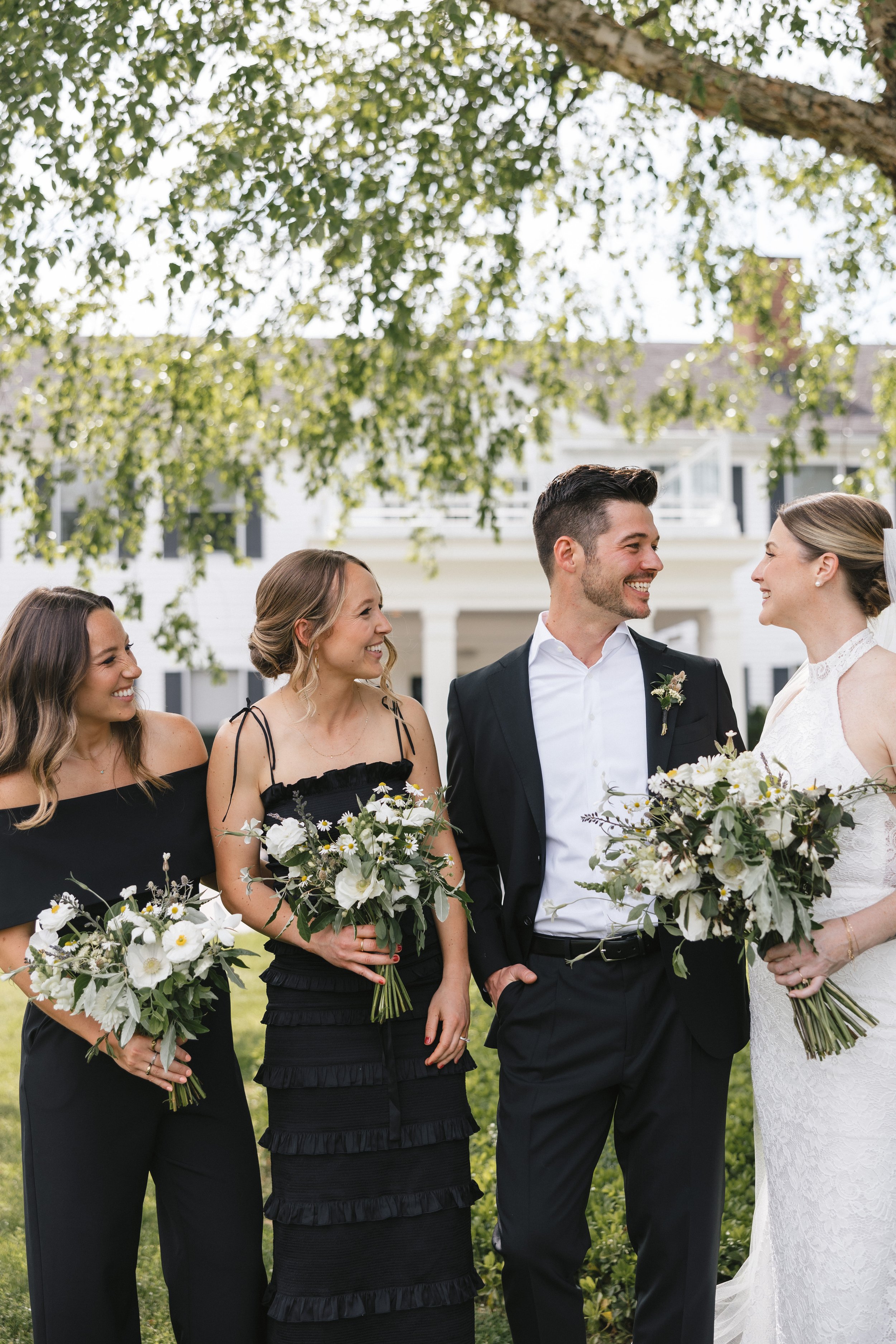 A photo captures the wedding party with lush timeless wedding florals at a Litchfield Inn wedding, one of our favorite wedding locations in CT