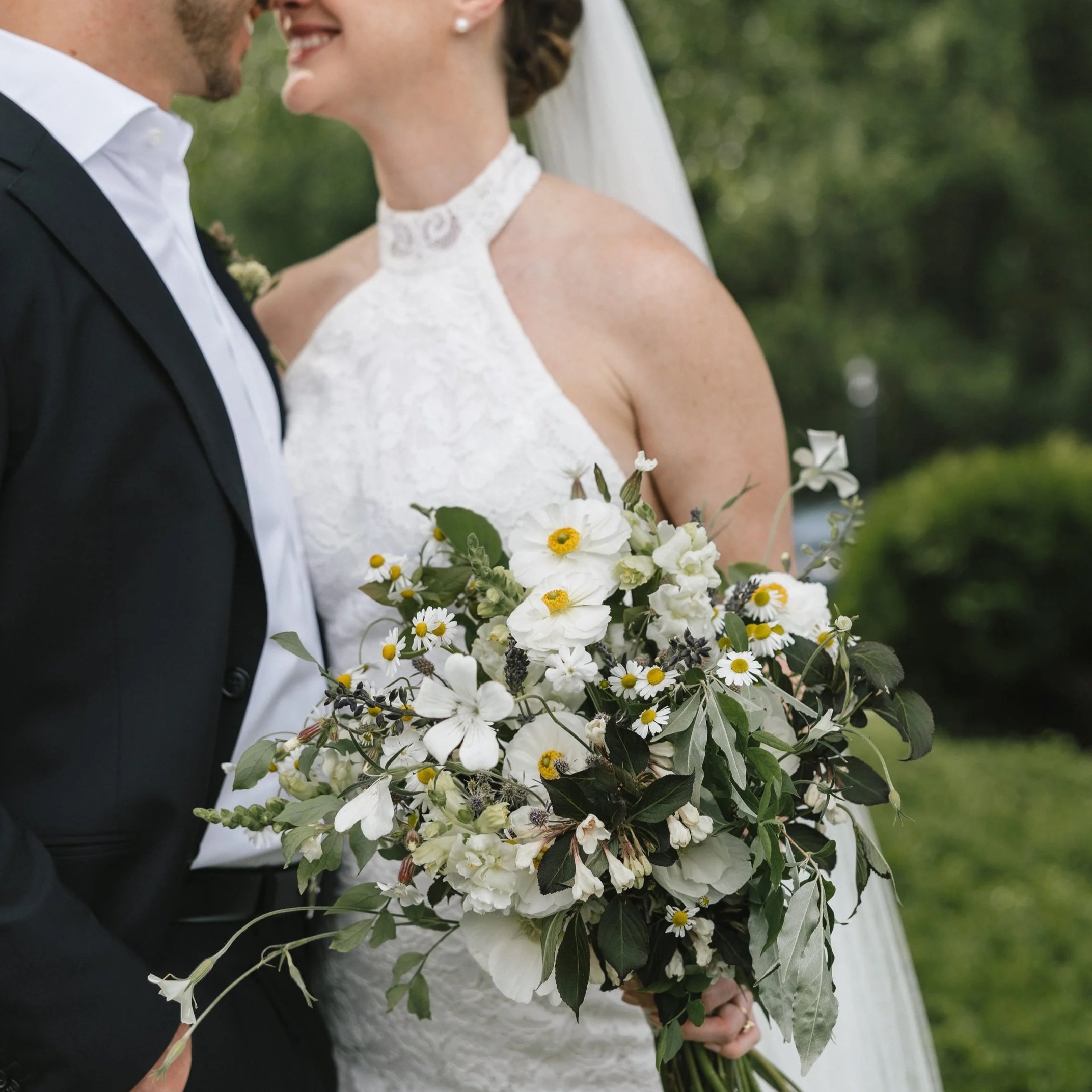 A bride and groom on their wedding day, with the bride holding an artistically designed bridal bouquet for the Litchfield Inn wedding