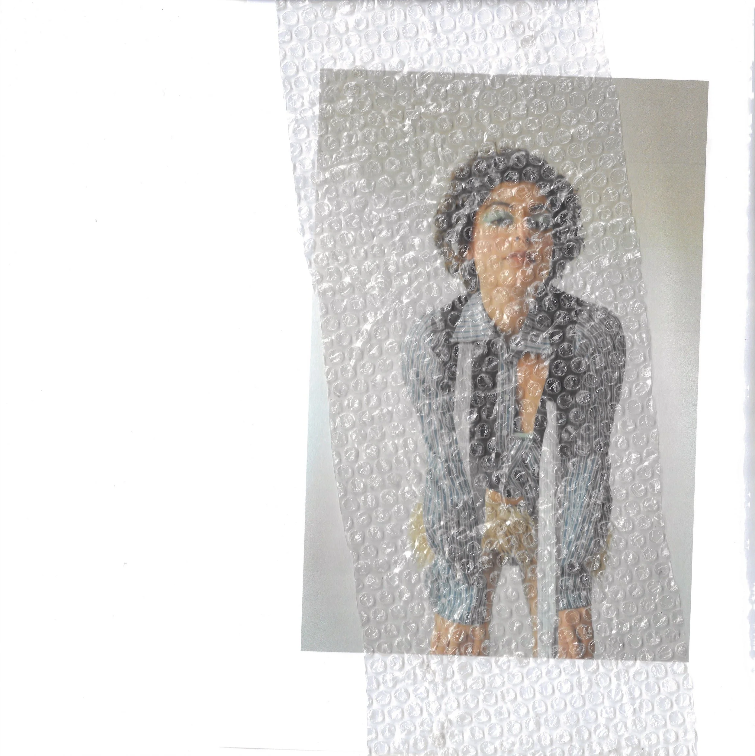 A person wearing glasses and a striped shirt is wrapped in bubble wrap.