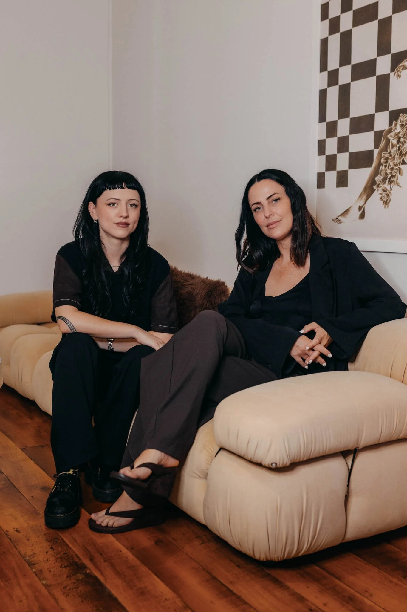 two women modelling sitting on couch in waiting room of their skin clinic Valli House