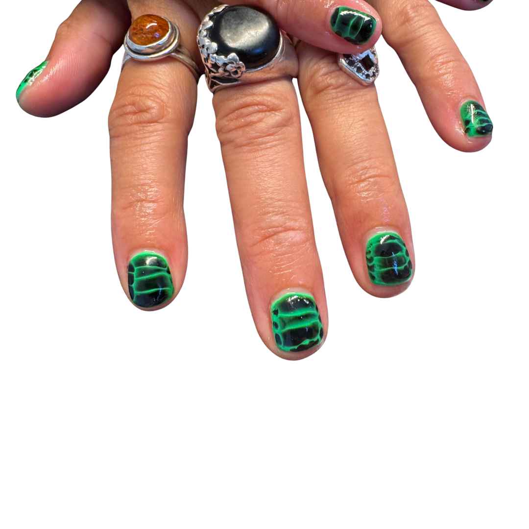 black and green brat croc or reptile print short nails with cool rings and jewellery