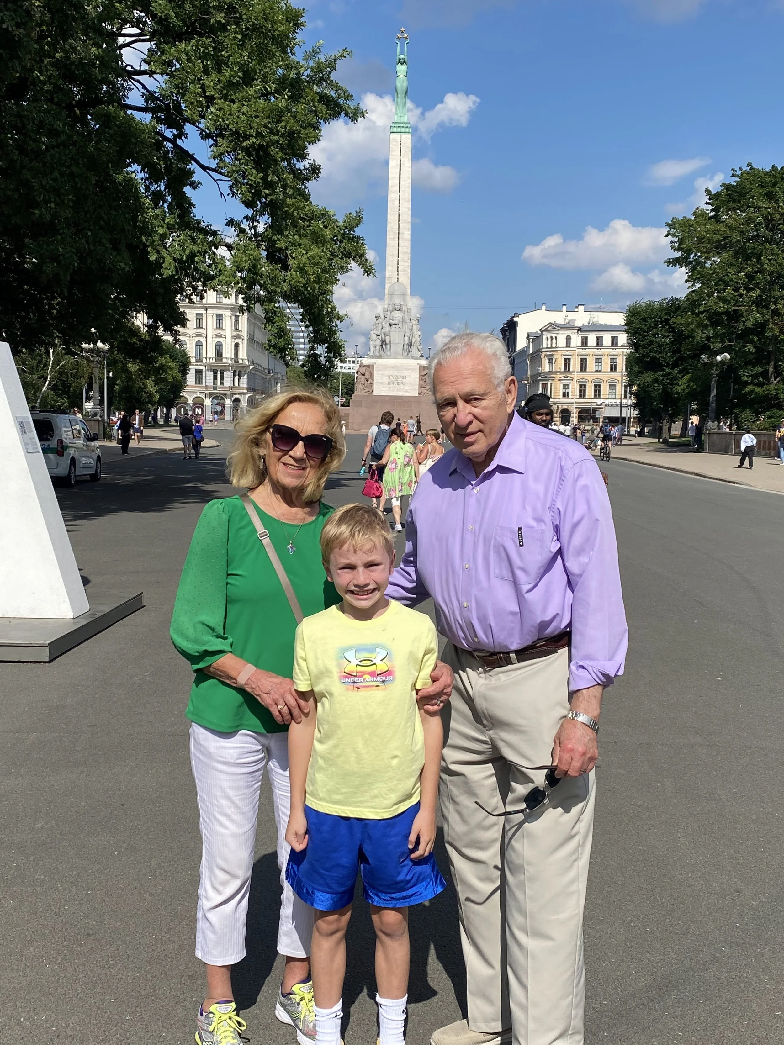 Daggie, Little Andris, and Andris at Latvian Freedom monument which survived Soviet times. Latvians who left flowers by monument were whisked away by KGB. August 2, 2025