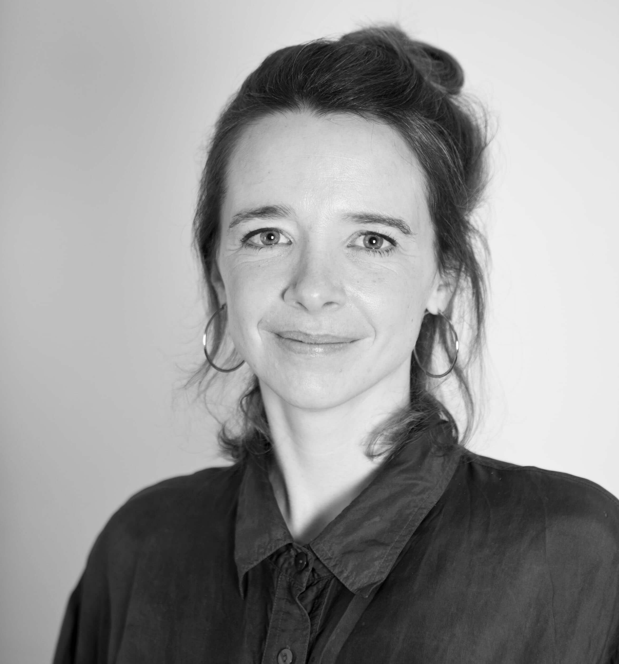 Frau in schwarzem Shirt lächelt freundlich in die Kamera.