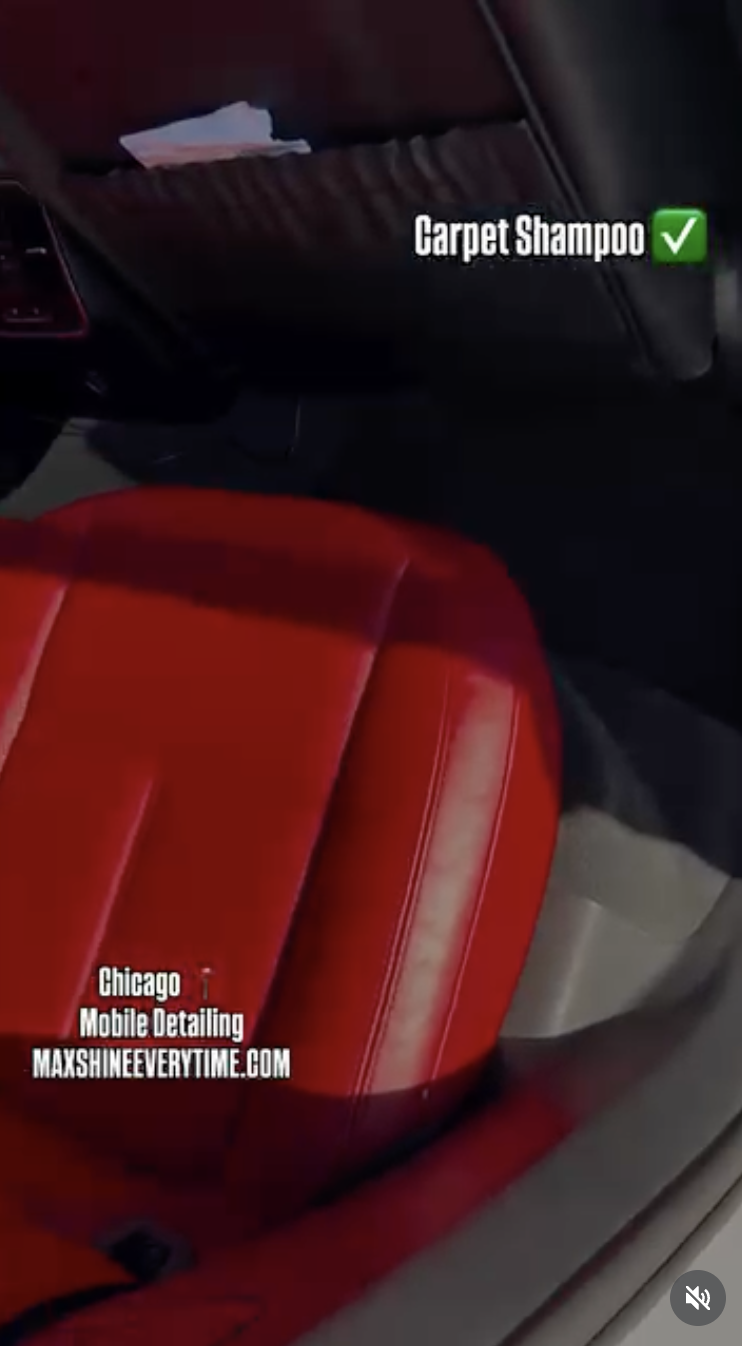 Close-up of a red car seat in a vehicle, with a pocket on the back of the front seat containing some papers and a label indicating "Carpet Shampoo" with a check mark.