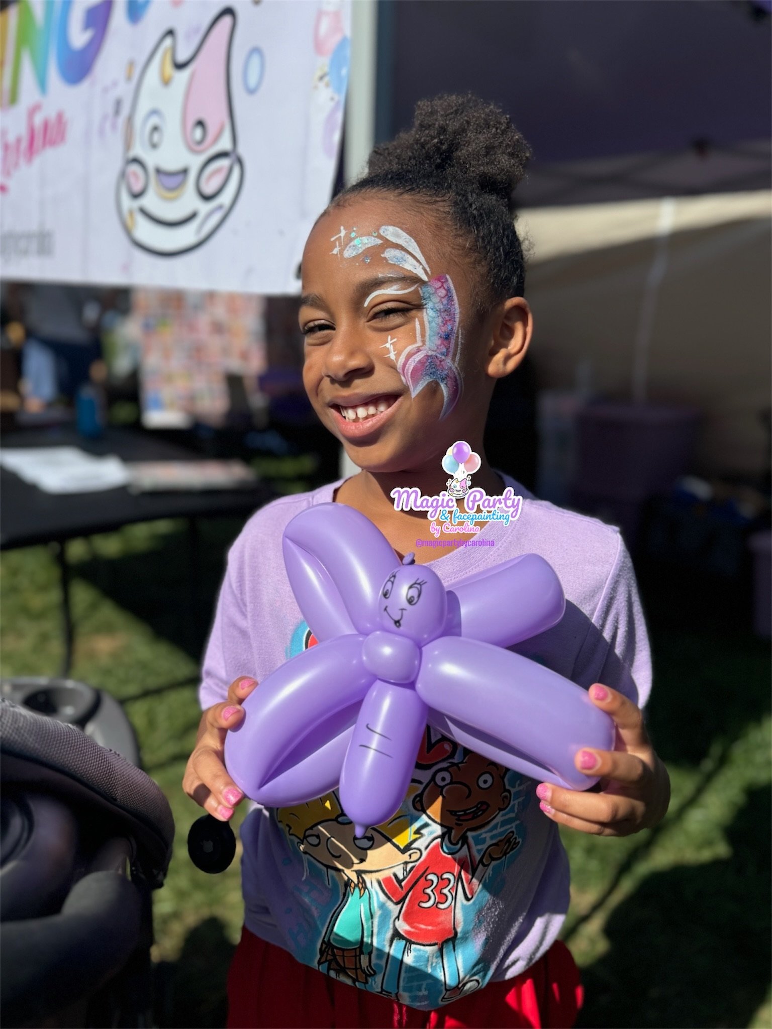 Child with face paint and balloon at outdoor event