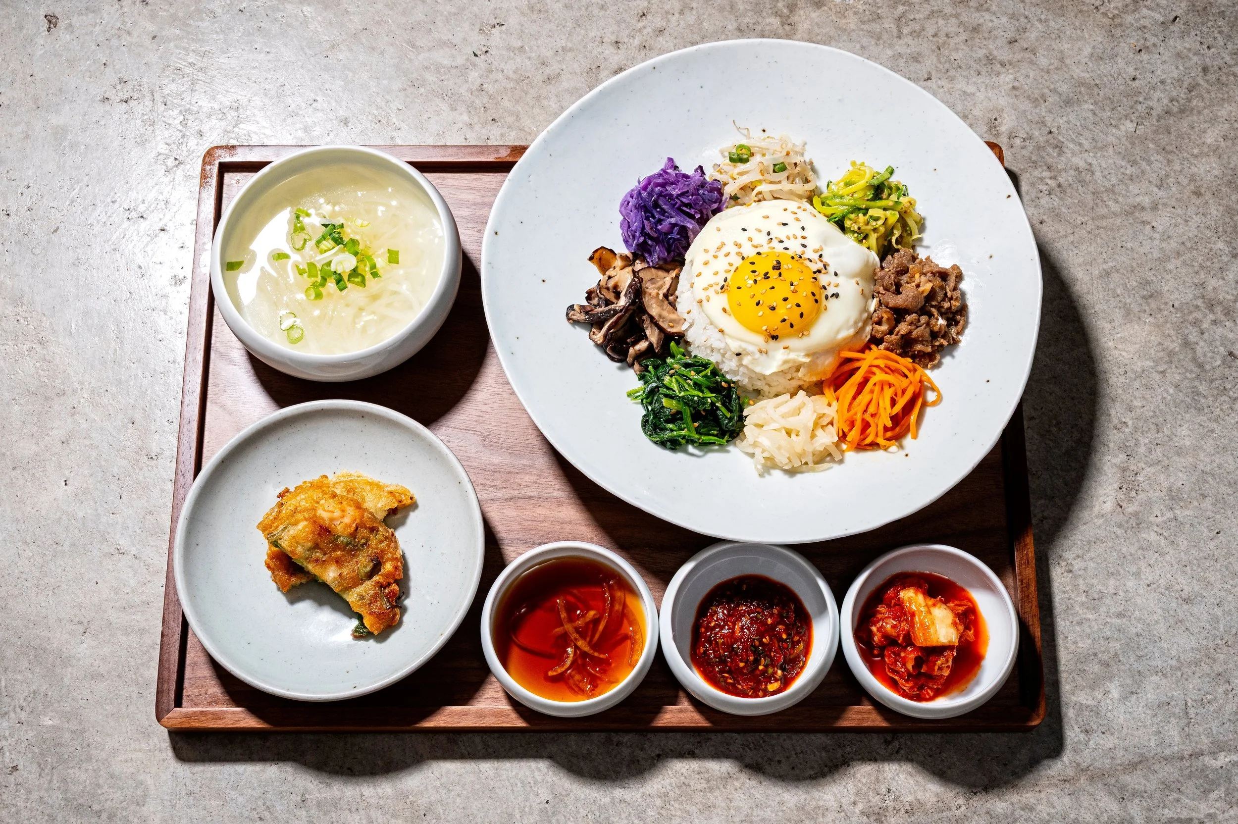  BIBIMBAP JEONGSIK SET 비빔밥 정식 세트  
Rice bowl with sautéed vegetables served with three side dishes, soup of the day, jeon (savory pancake), and your choice of protein (beef, egg, or tofu). Bibimbap is also available as an individual dish on the à la 