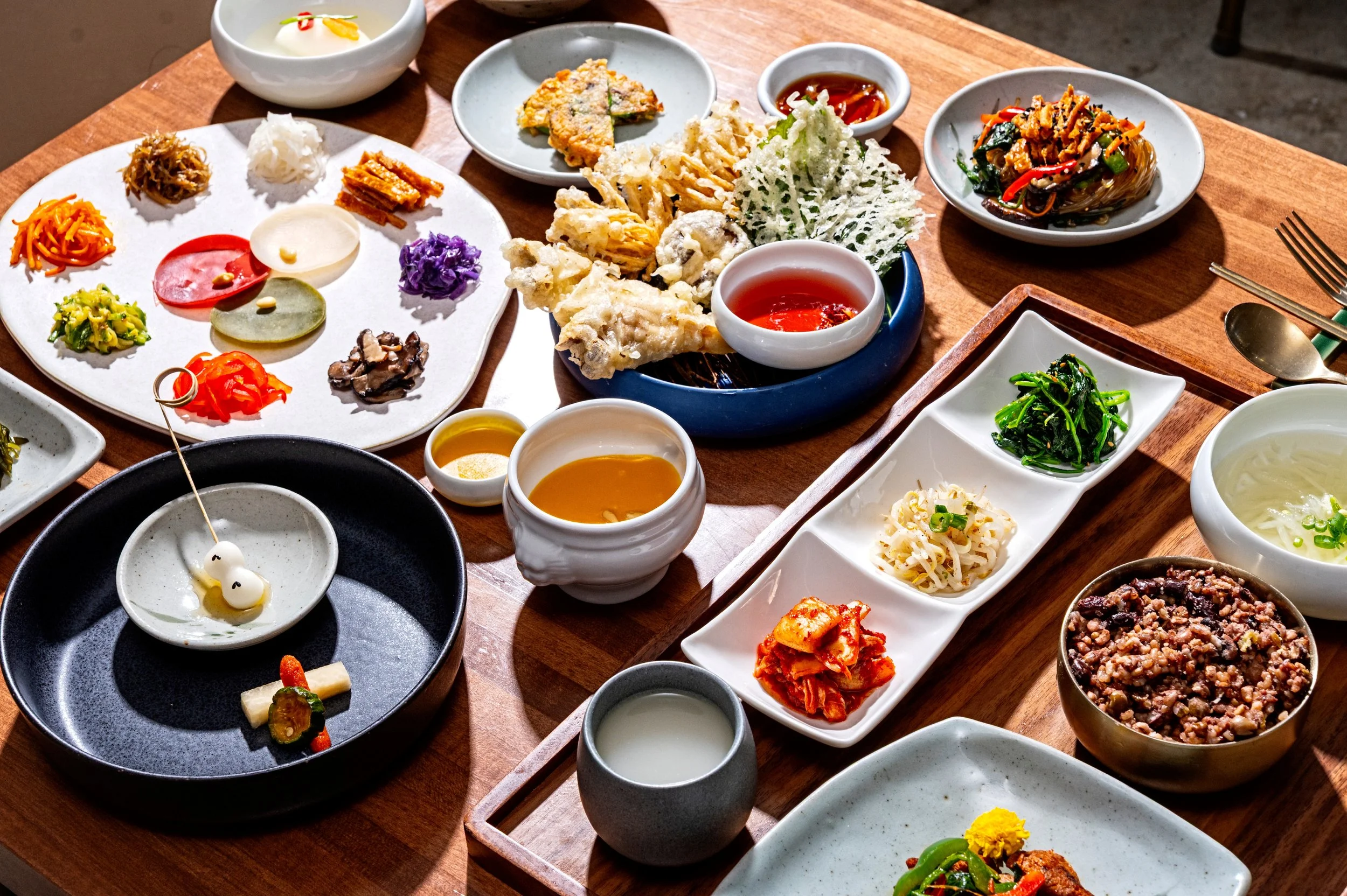 A full vegan Hanjeongsik 6-course meal at Onggi in Washington DC, featuring a variety of traditional Korean dishes including soups, grilled meats, vegetables, rice, and banchan. A thoughtfully prepared multi-course dining experience showcasing the de
