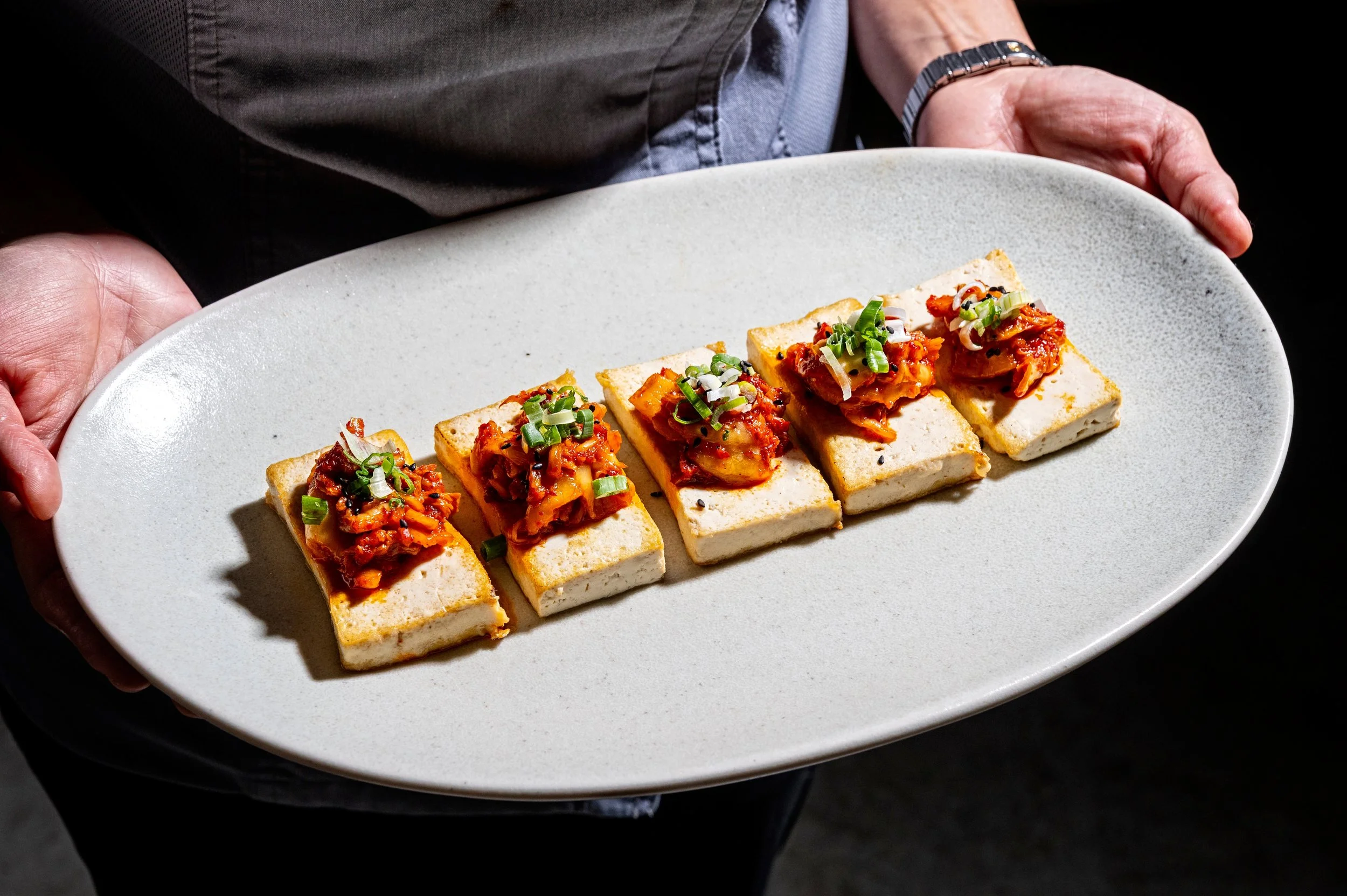 Pan-seared tofu with a golden crust, served with housemade kimchi at Onggi in Washington DC. A simple yet flavorful Korean-inspired dish highlighting texture and taste.
