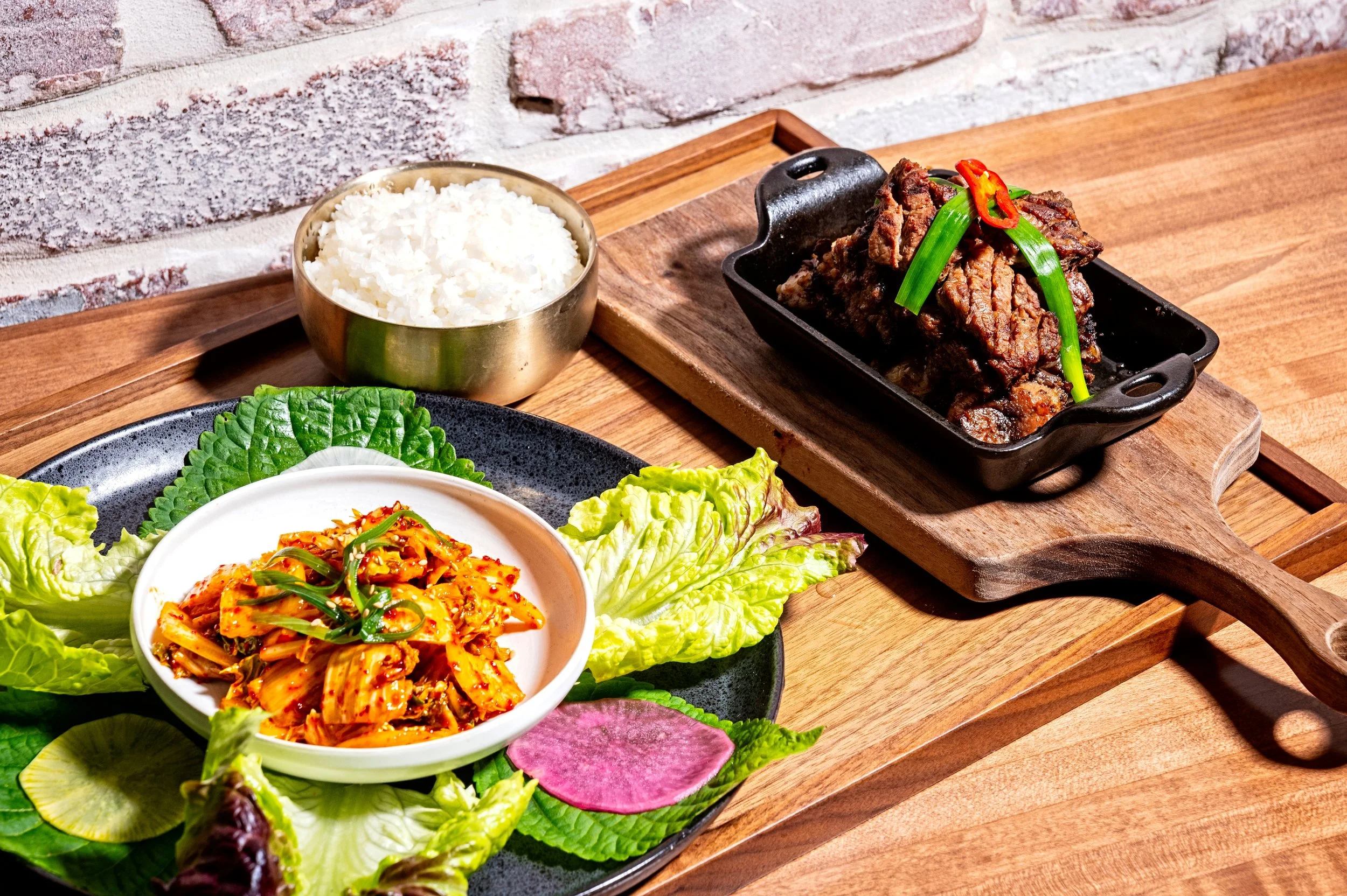 Grilled Galbi (Korean marinated short ribs) served with fresh lettuce, perilla leaves, kimchi, and a bowl of steamed rice at Onggi in Washington DC. A flavorful Korean barbecue favorite perfect for sharing.