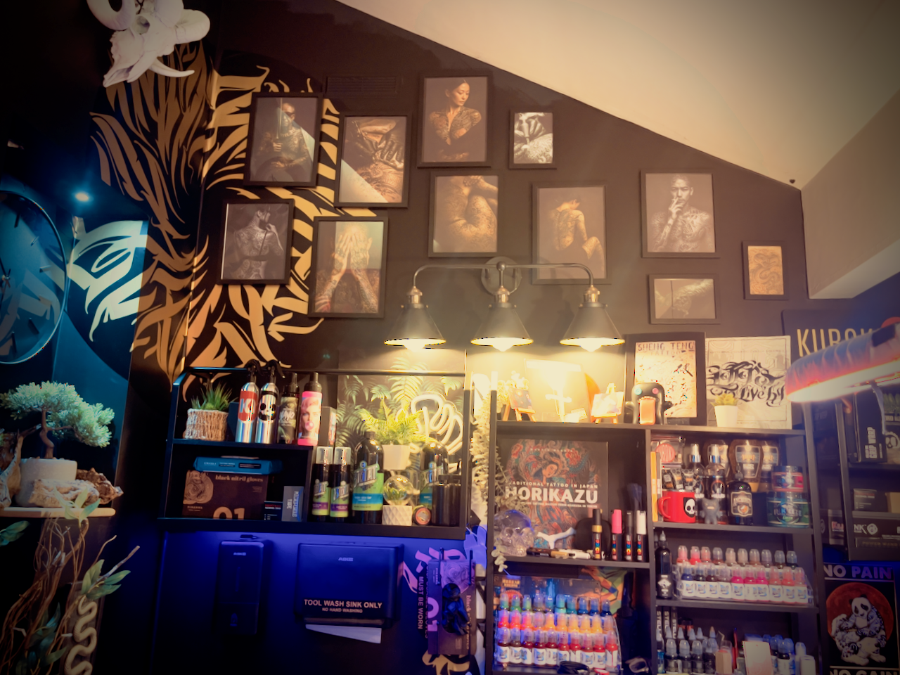 Wide view of Kuroko Ink studio wall with framed artwork and display area