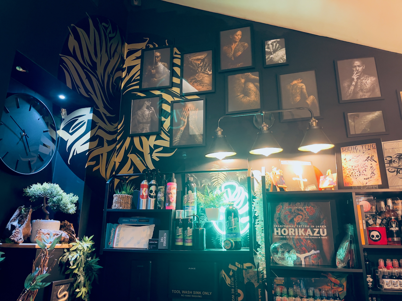 Kuroko Ink studio interior with neon display, framed artwork, and shelving